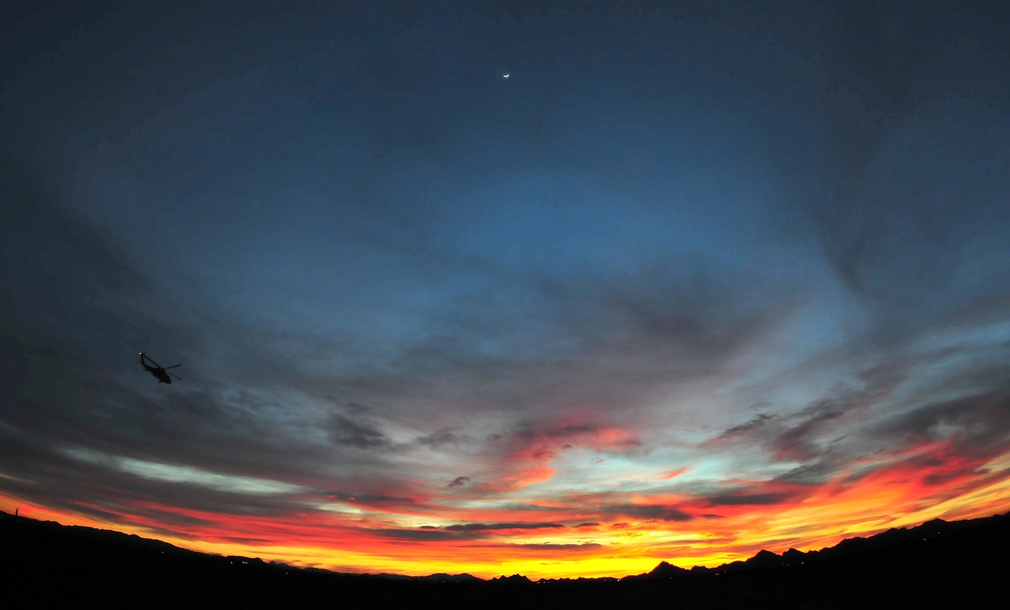 DAVIS-MONTHAN AIR FORCE BASE, Arizona - A rescue helicopter heads out of Davis-Monthan Air Force Base, Tucson, Arizona, March 4, 2014, for a night training flight under a crescent moon. (U.S. Air Force photo/Tech. Sgt. Frank Oliver)
