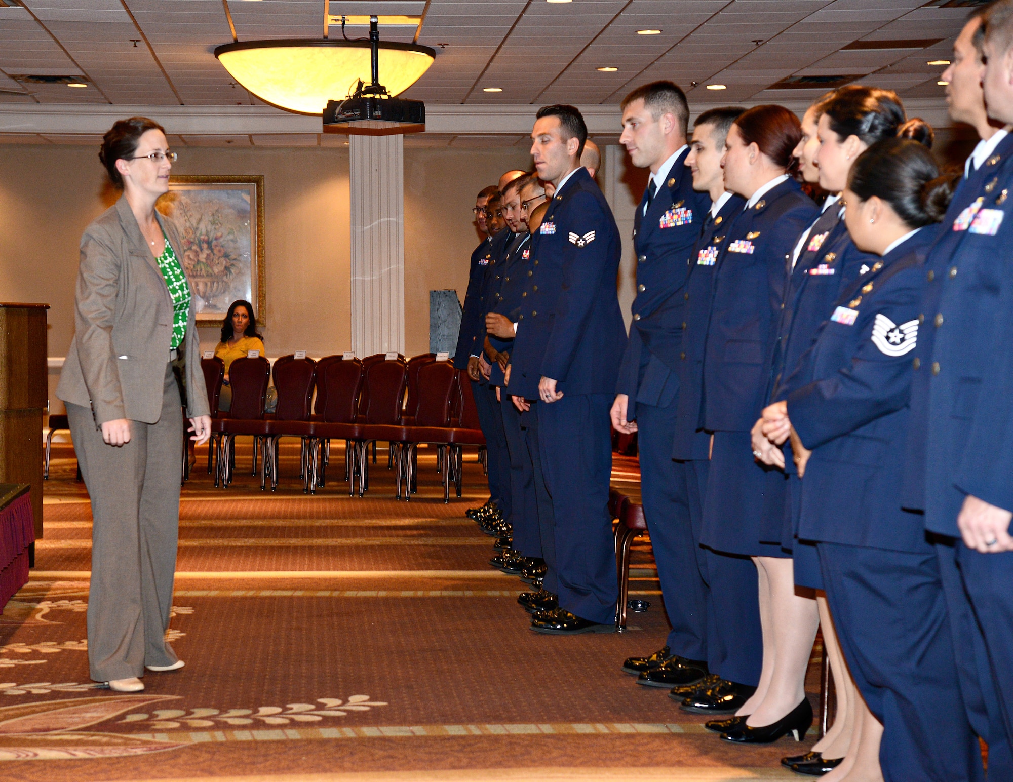 Jennifer Collins, with the 72nd Air Base Wing Protocol Office, runs through correct procedures with graduates at a recent Community College of the Air Force graduation ceremony. (Air Force photo by Kelly White)