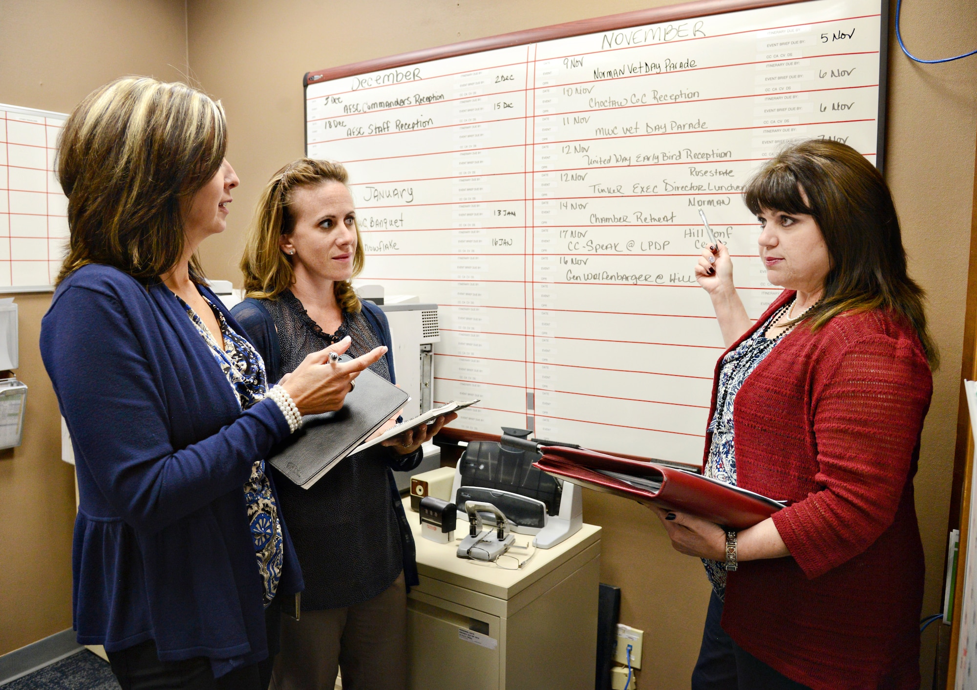Rhonda Lugo, Air Force Sustainment Center chief of Protocol, right, reviews upcoming events with members of her staff, Tonja Nichols, left, and Melissa Hancock, to assure that all the details for the events will be handled properly. (Air Force photo by Kelly White)