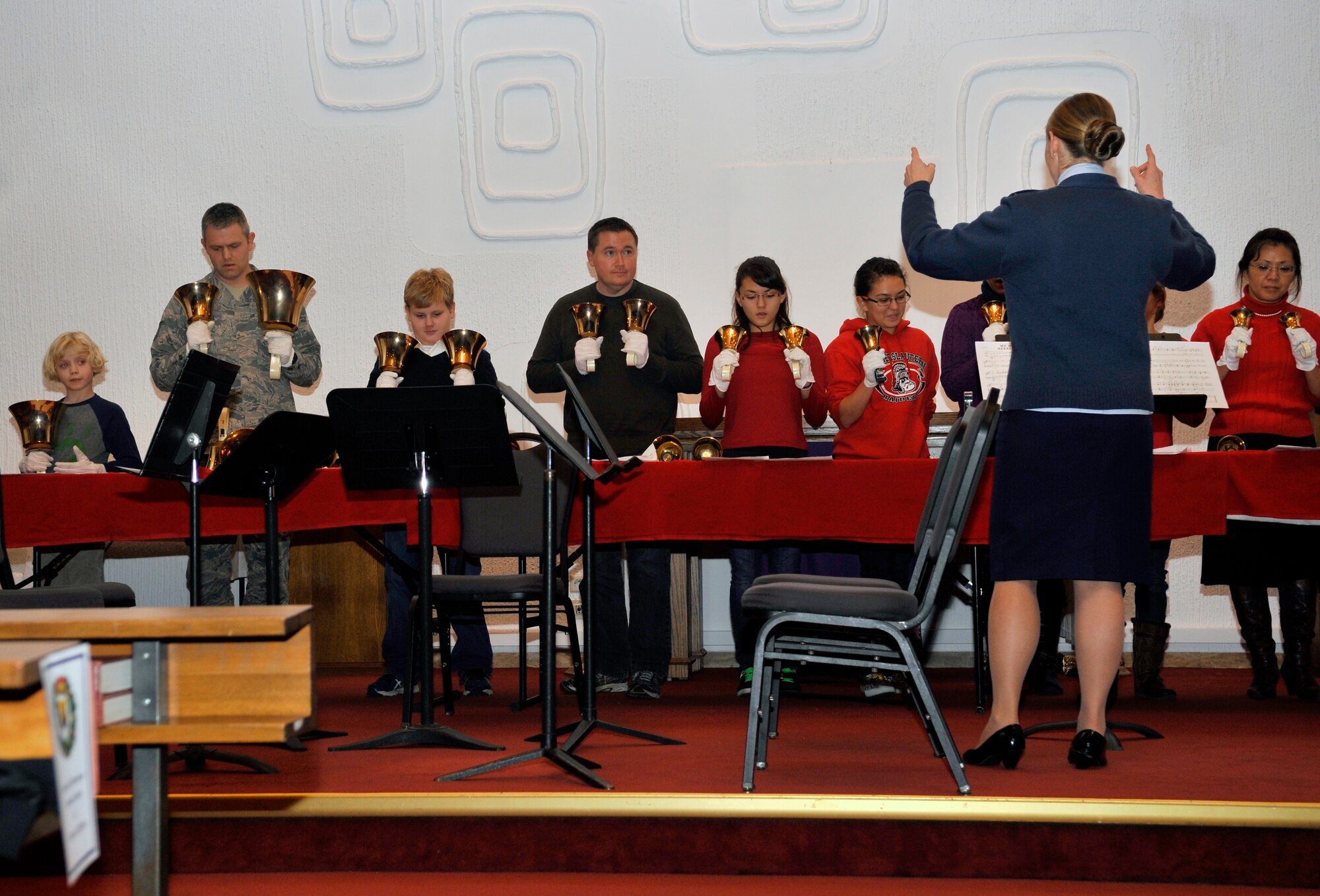 Children, civilians and military member volunteers perform holiday song renditions as a bell choir during the tree lighting ceremony, Dec. 1, 2014 at Ramstein Air Base, Germany. The event consisted of musical performances, the tree lighting ceremony, a meet-and-greet with Santa and cookies and hot cocoa. (U.S. Air Force photo/Airman 1st Class Larissa Greatwood)