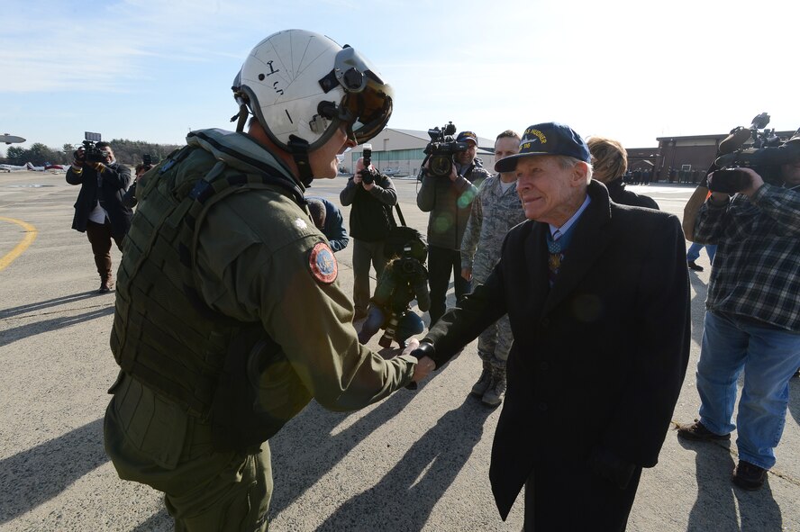 U.S. Navy Commander Peter Hagge, commanding officer of Strike Fighter Squadron 32, is greeted by Medal of Honor recipient retired U.S. Navy Capt. Thomas Hudner Jr. at Hanscom Air Force Base, Mass., Dec. 4, 2014. Hagge is the weapons systems officer of the F-18F Super Hornet that bears the name of Hudner on one side and Ensign Jesse Brown, the pilot Hudner tried to rescue, on the other. SFS 32 is the descendant of the unit Hudner flew with during the Korean War. Hanscom hosted the event on the 64th anniversary of the Korean War actions that earned Hudner his Medal of Honor. (U.S. Air Force photo/Jerry Saslav) 
