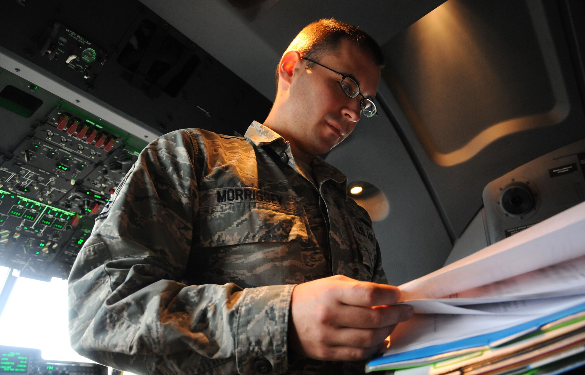U.S. Air Force Staff Sgt. Andrew Morrissey, 352nd Special Operations Maintenance Squadron flying crew chief from Coral Springs, Fla., checks aircraft paperwork for an MC-130J Commando II Oct. 21, 2014, on RAF Mildenhall, England. Morrissey reviews aircraft forms to ensure the aircraft is safe for flight. (U.S. Air Force photo illustration by Gina Randall/Released)