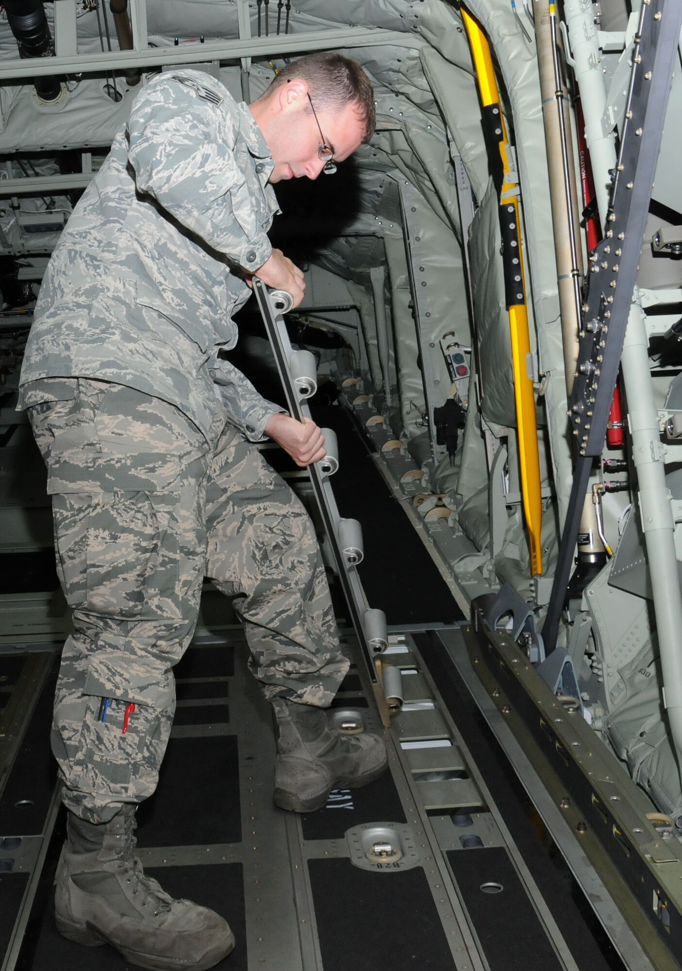 U.S. Air Force Staff Sgt. Andrew Morrissey, 352nd Special Operations Maintenance Squadron flying crew chief from Coral Springs, Fla., prepares aircraft for cargo pallets by inspecting the rails system on an MC-130J Commando II Oct. 21, 2014, on RAF Mildenhall, England. Morrissey maintains aircraft at home and off-station. (U.S. Air Force photo by Gina Randall/Released)