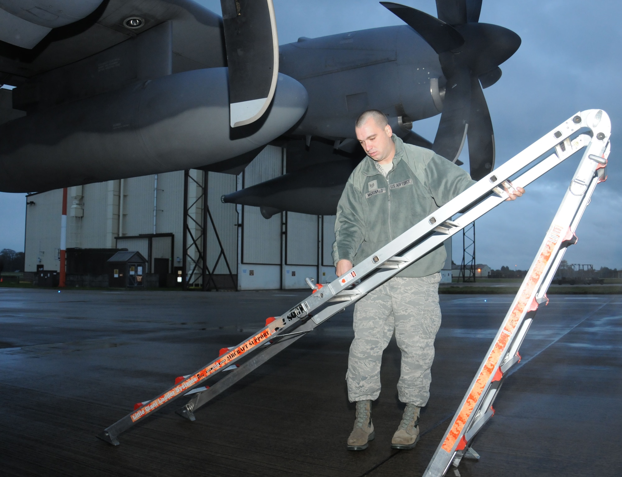 U.S. Air Force Staff Sgt. Randy McDonald, 352nd Special Operations Maintenance Squadron dedicated crew chief from Sumter, S.C., moves a ladder into position to inspect a propeller of an MC-130J Commando II Oct. 21, 2014, on RAF Mildenhall, England. Each aircraft is assigned its own dedicated crew chief whose job it is to ensure the aircraft is mission ready in any condition. (U.S. Air Force photo by Gina Randall/Released)