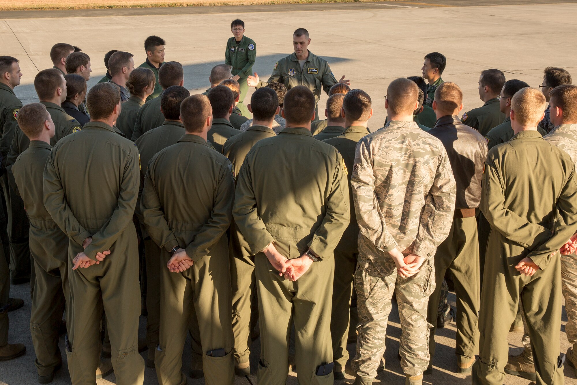 U.S. Air Force Lt. Col. Andrew Campbell, 36th Airlift Squadron commander, talks to U.S. Air Force and Japan Air Self-Defense Force members at Yokota Air Base, Japan, Dec. 3, 2014. JASDF members from the 401st Squadron delivered Operation Christmas Drop donations as part of 40 tons of humanitarian aid headed to various austere locations throughout the Pacific. (U.S. Air Force photo by Osakabe Yasuo/Released)