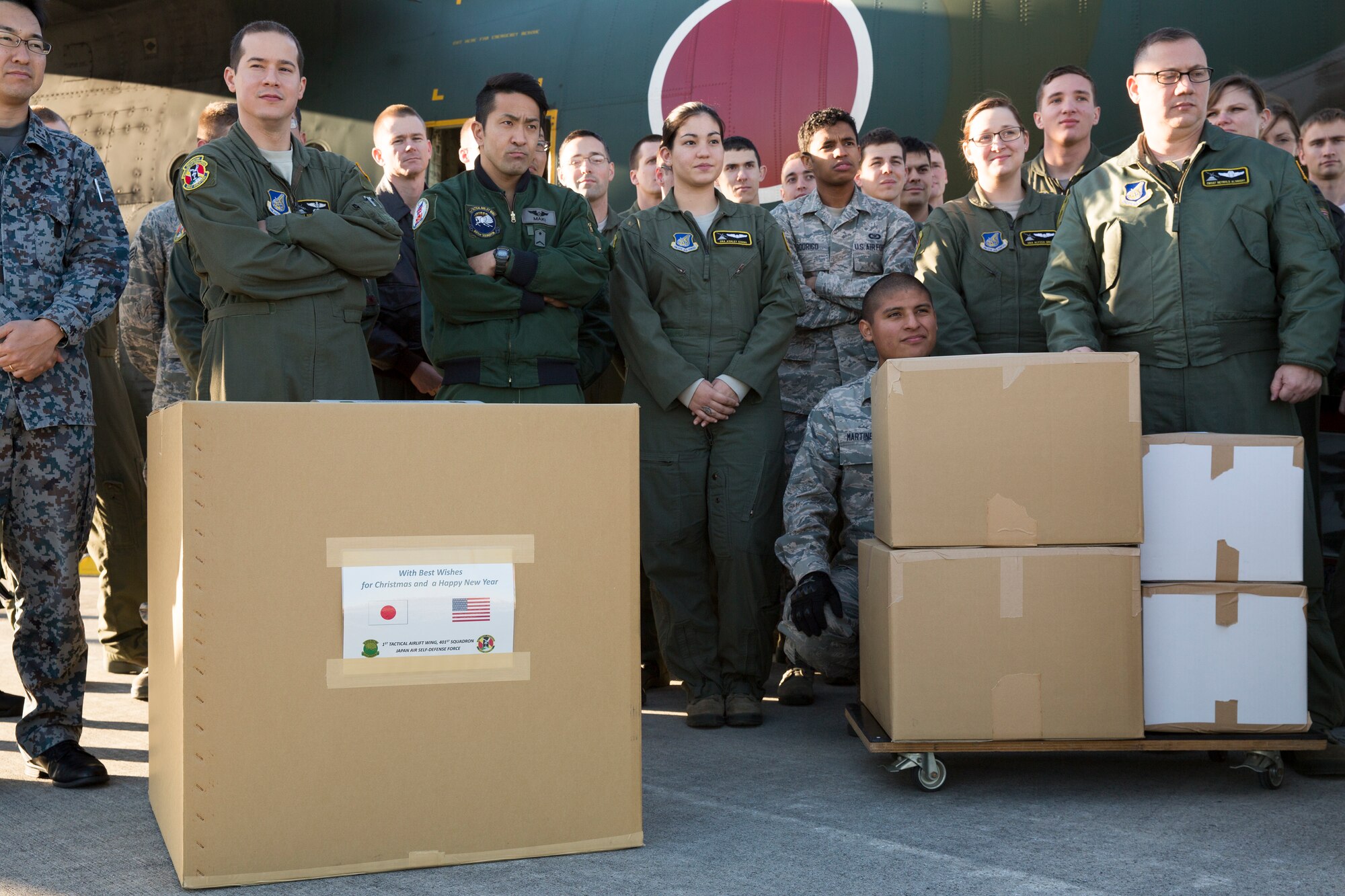 U.S. Air Force and Japan Air Self-Defense Force airmen get briefed in front of a JASDF C-130 Hercules at Yokota Air Base, Japan, Dec. 3, 2014. JASDF members from the 401st Squadron delivered Operation Christmas Drop donations as part of 40 tons of humanitarian aid headed to various austere locations throughout the Pacific. (U.S. Air Force photo by Osakabe Yasuo/Released)