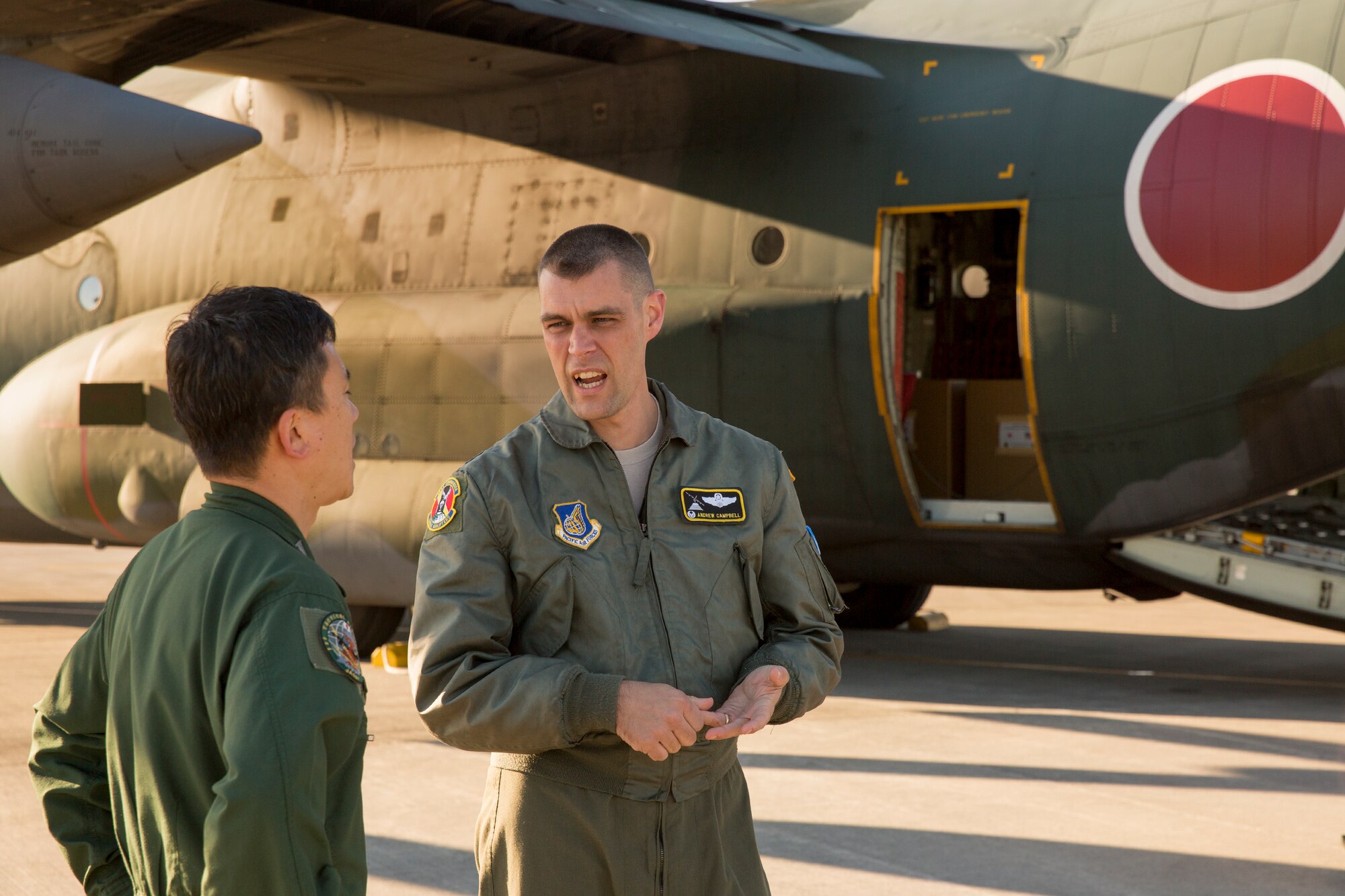 U.S. Air Force Lt. Col. Andrew Campbell, 36th Airlift Squadron commander, talks to Japan Air Self-Defense Force Lt. Col. Hitoshi Uchiyama, 401st Squadron commander, Dec. 3, 2014, at Yokota Air Base, Japan. JASDF members from the 401st Squadron delivered Operation Christmas Drop donations as part of 40 tons of humanitarian aid headed to various austere locations throughout the Pacific. (U.S. Air Force photo by Osakabe Yasuo/Released)