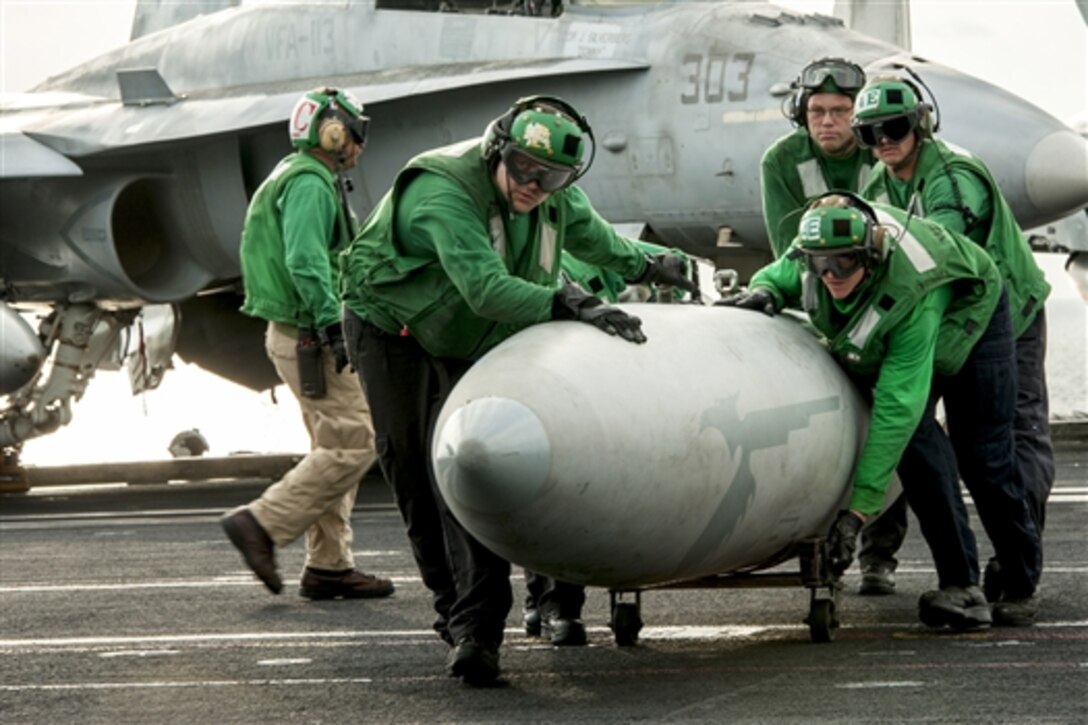 U.S. sailors move an aircraft fuel tank across the flight deck of the of the aircraft carrier USS Carl Vinson in the Persian Gulf, Nov. 24, 2014.