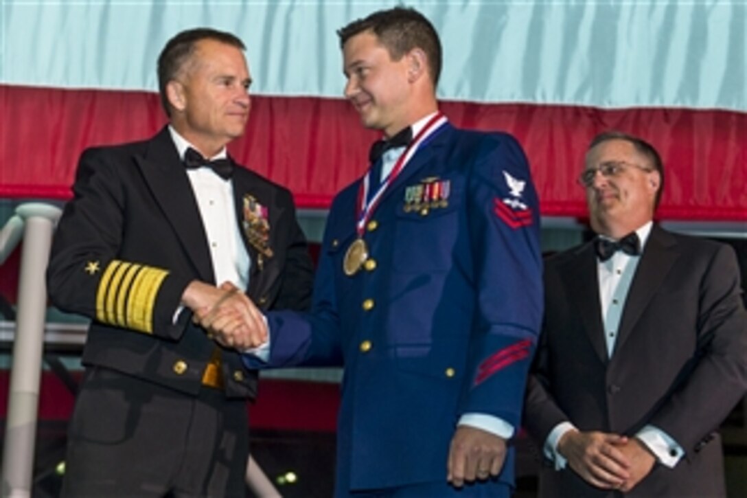 Navy Adm. James A. Winnefeld Jr., vice chairman of the Joint Chiefs of Staff, congratulates Coast Guard Petty Officer 2nd Class Michael Allen during the USO’s 53rd Armed Forces Gala and Gold Medal Dinner in New York, Dec. 4, 2014. Allen, an avionics electrical technician, was one of five service members to receive a USO Military leadership award. 