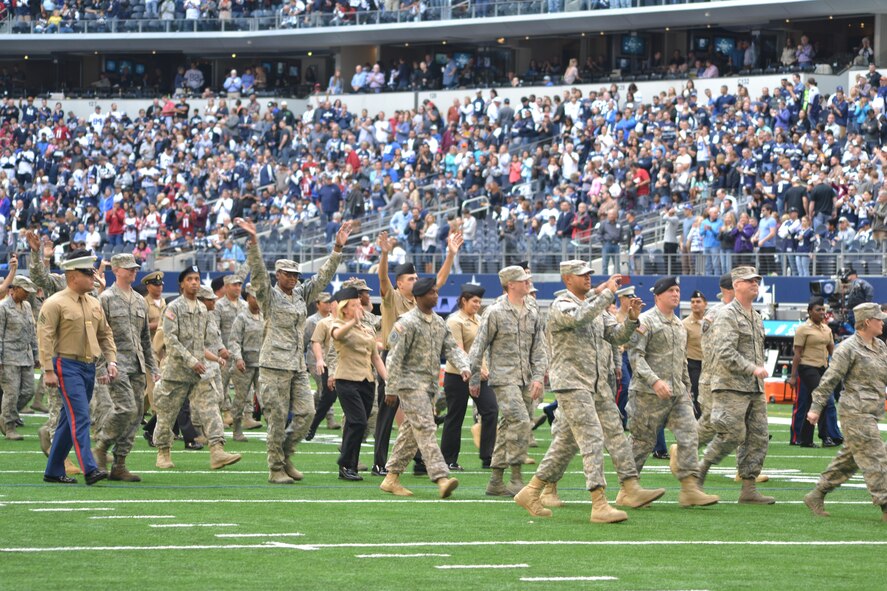 More than 400 servicemembers from all four major branches participate in an on-field joint service halftime event during the Dallas Cowboys' Veterans Appreciation game in Arlington, Texas Nov. 2, 2014.  The Air Force Band of the West played each branch's march as their service's shield was displayed on a large banner.  Participants were primarily individuals assigned to various units located on Naval Air Station Joint Reserve Base, Fort Worth, Texas. (U.S. Air Force photo by Mr. Shawn McCowan)