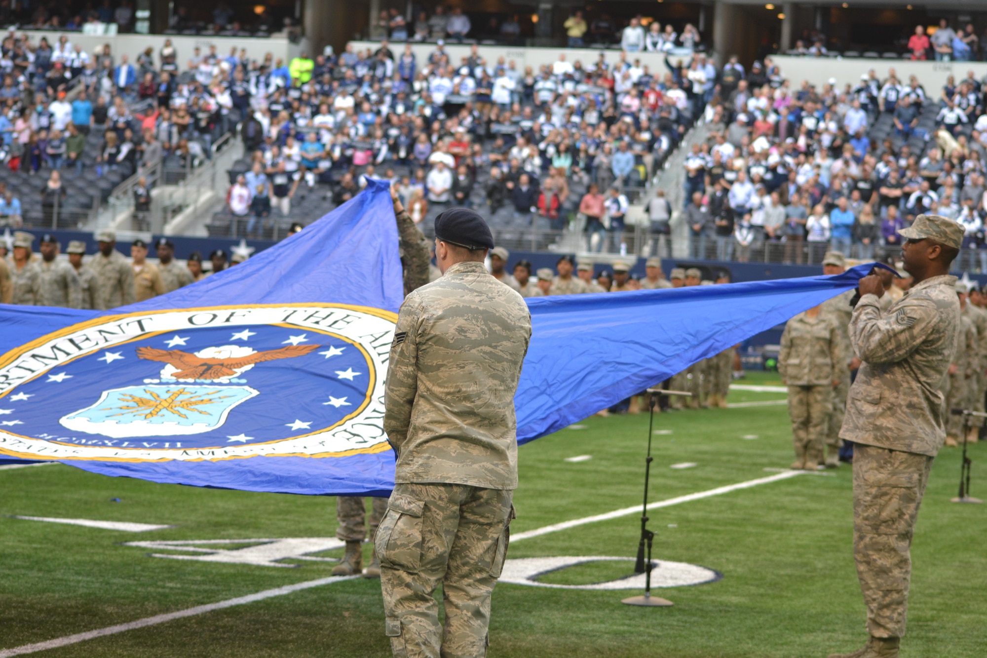 More than 400 servicemembers from all four major branches participate in an on-field joint service halftime event during the Dallas Cowboys' Veterans Appreciation game in Arlington, Texas Nov. 2, 2014.  The Air Force Band of the West played each branch's march as their service's shield was displayed on a large banner.  Participants were primarily individuals assigned to various units located on Naval Air Station Joint Reserve Base, Fort Worth, Texas. (U.S. Air Force photo by Mr. Shawn McCowan)