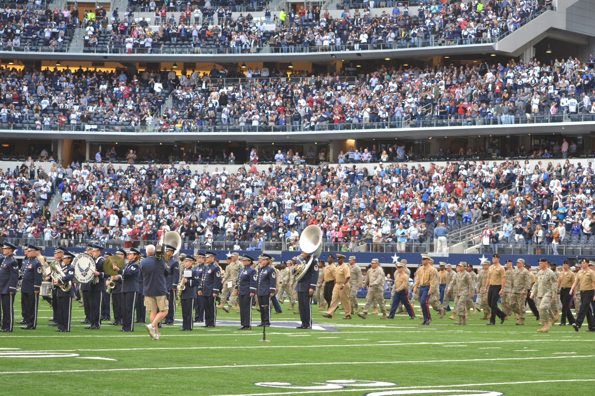 More than 400 servicemembers from all four major branches participate in an on-field joint service halftime event during the Dallas Cowboys' Veterans Appreciation game in Arlington, Texas Nov. 2, 2014.  The Air Force Band of the West played each branch's march as their service's shield was displayed on a large banner.  Participants were primarily individuals assigned to various units located on Naval Air Station Joint Reserve Base, Fort Worth, Texas. (U.S. Air Force photo by Mr. Shawn McCowan)