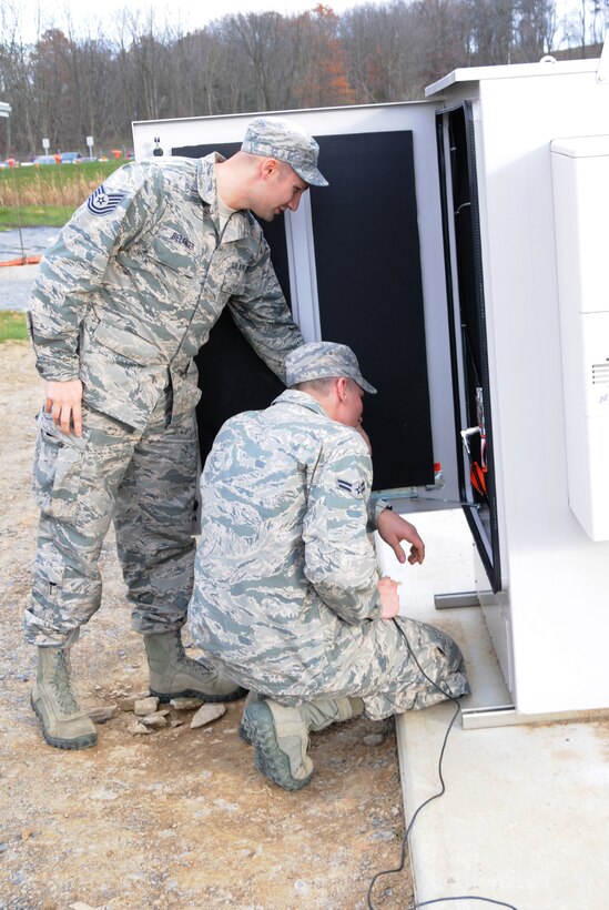 Tech. Sgt. Nathan Belanger and Airman 1st Class Patrick Kluyber, radio frequency transmission systems Airmen, 148th Air Support Operations Squadron, connect the antenna used during Exercise Noble Skywave 2014. The two-man team captured first place in the global exercise that focuses on high-frequency radio communications. (U.S. Air National Guard photo by Staff Sgt. Claire Behney/Released)