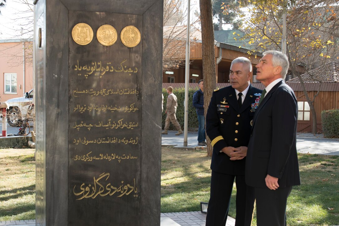 U.S. Army Gen. John F. Campbell, left, commander of the International Security Assistance Force and U.S. Forces Afghanistan, shows U.S. Defense Secretary Chuck Hagel a monument dedicated to fallen soldiers at the ISAF headquarters in Kabul, Afghanistan, Dec. 6, 2014.
