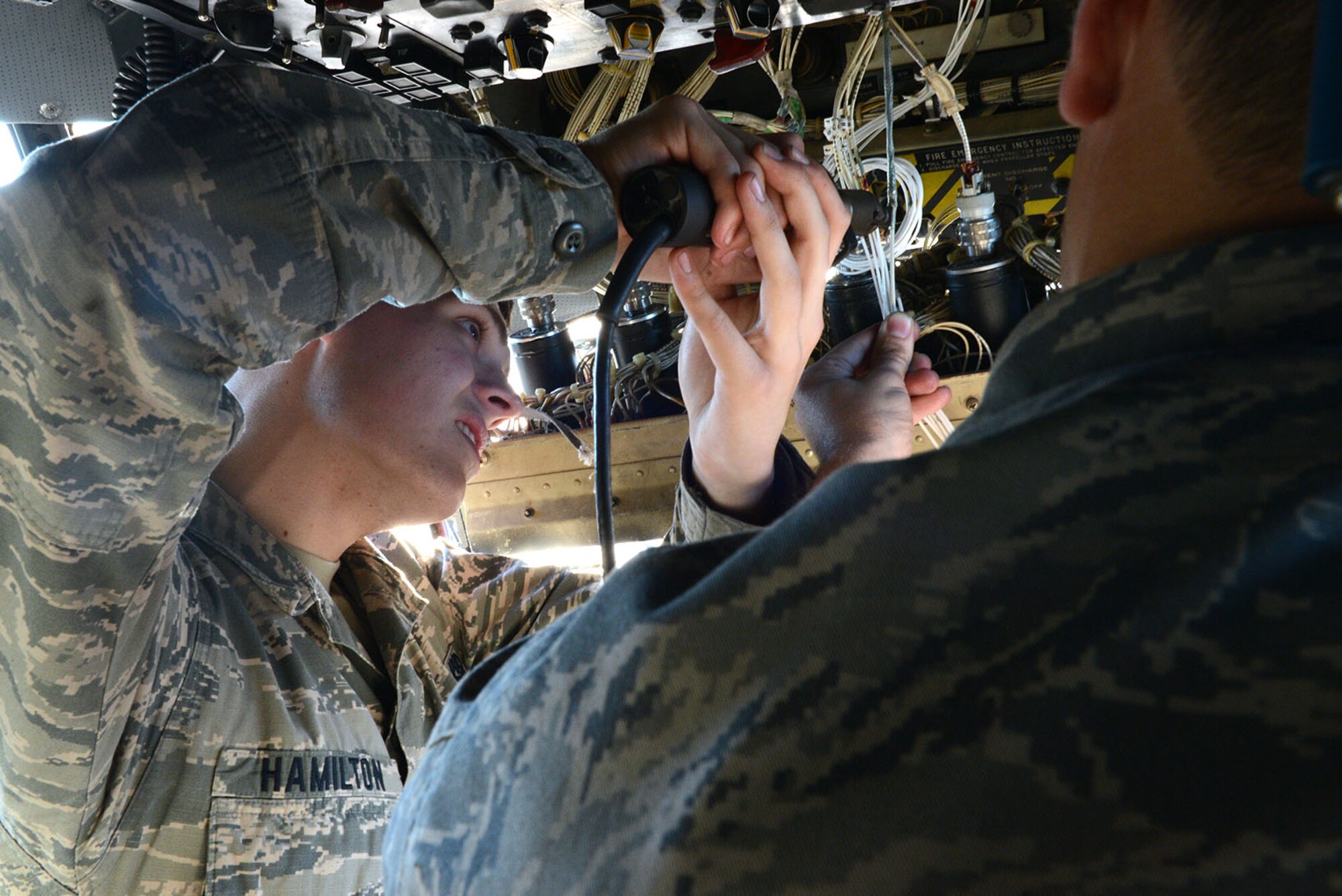 Airman 1st Class Andrew Hamilton, 374th Aircraft Maintenance Squadron instruments and flight controls apprentice, solders together a wire on a fuel quantity indication connector of a C-130 Hercules at Yokota Air Base, Japan, Dec. 2, 2014. Wires are soldered together to create a high quality electrical connection for various systems on the C-130. (U.S. Air Force photo by Senior Airman Desiree Economides/Released)