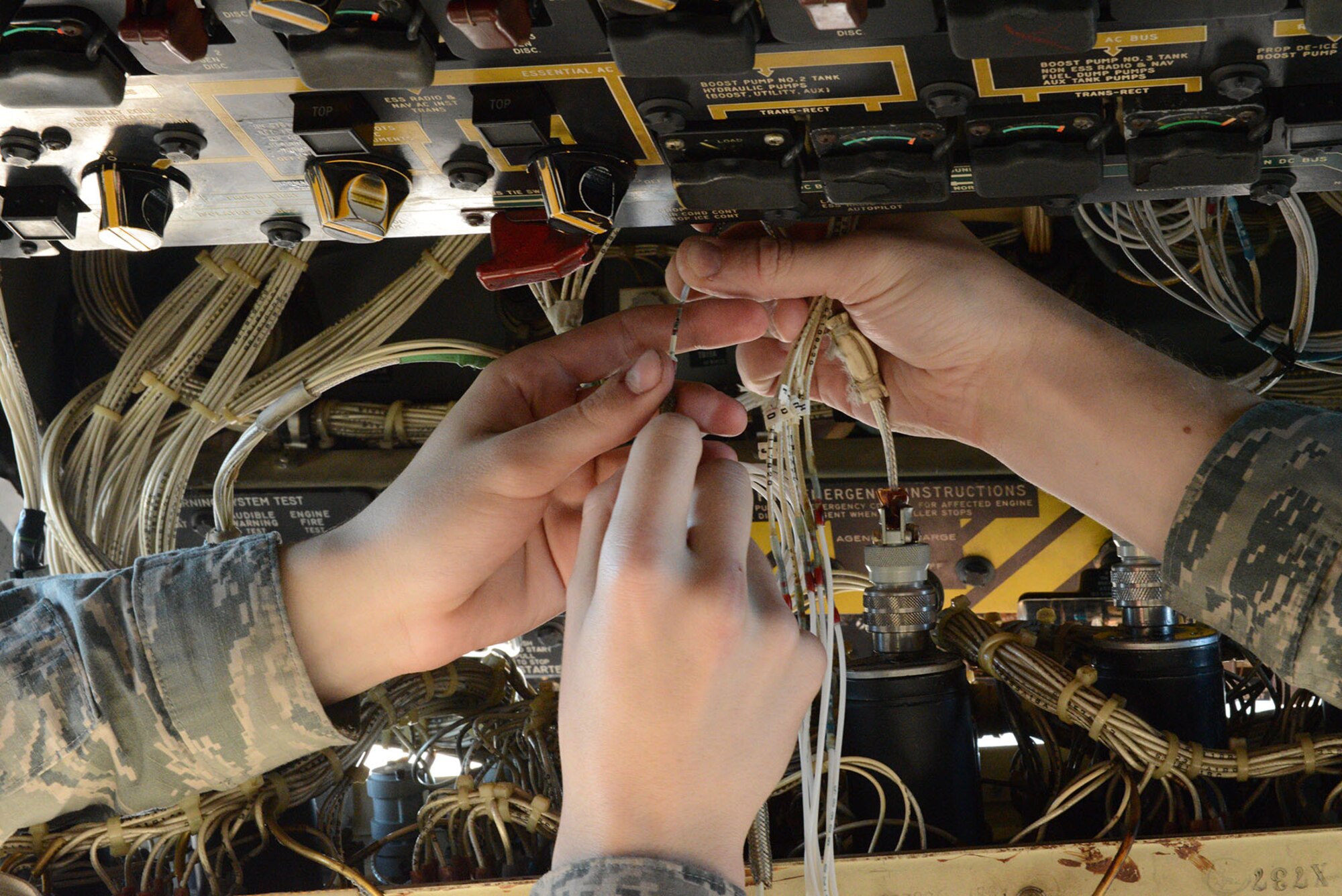 Airmen work together to replace the wires on a fuel quantity indicator on a C-130 Hercules at Yokota Air Base, Japan, Dec. 2, 2014. Maintainers in the 374th Aircraft Maintenance Squadron provide scheduled and unscheduled maintenance to C-130s assigned to Yokota. (U.S. Air Force photo by Senior Airman Desiree Economides/Released) 