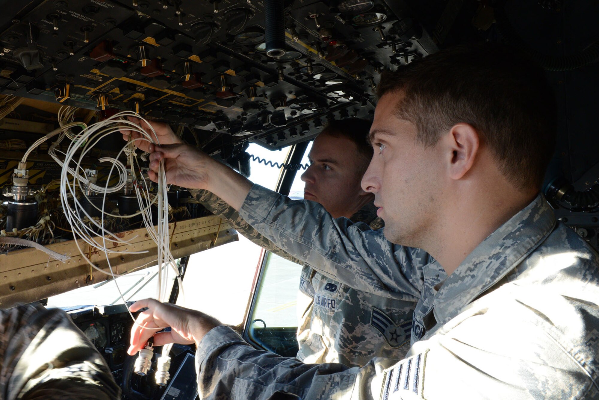 Right, Staff Sgt. Austin Carracino, 374th Aircraft Maintenance Squadron instruments and flight control systems craftsman, and Senior Airman Trey Massey, 374 AMXS instruments and flight control systems journeyman, measure a fuel quantity indication connector of a C-130 Hercules Dec. 2, 2014, at Yokota Air Base, Japan. The fuel quantity indicator tells pilots the level of fuel available for them during flight. (U.S. Air Force photo by Senior Airman Desiree Economides/Released)