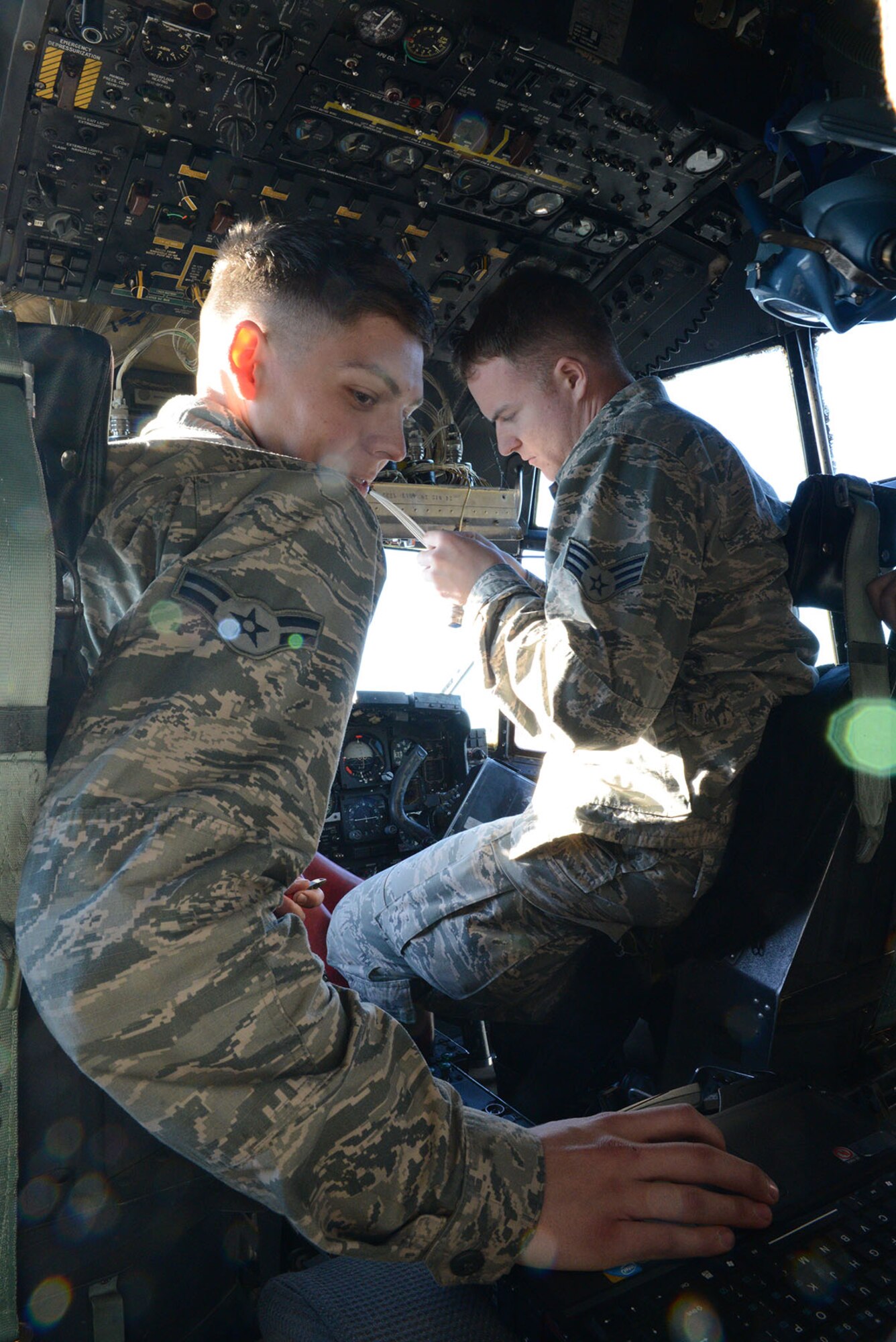 Airman 1st Class Andrew Hamilton, 374th Aircraft Maintenance Squadron instruments and flight controls apprentice, looks up a technical order for Senior Airman Trey Massey, 374 AMXS instruments and flight controls journeyman, Dec. 2, 2014, at Yokota Air Base, Japan. The 374 AMXS maintains C-130H models assigned to the 374th Airlift Wing at Yokota and other locations throughout the Pacific. (U.S. Air Force photo by Senior Airman Desiree Economides/Released)
