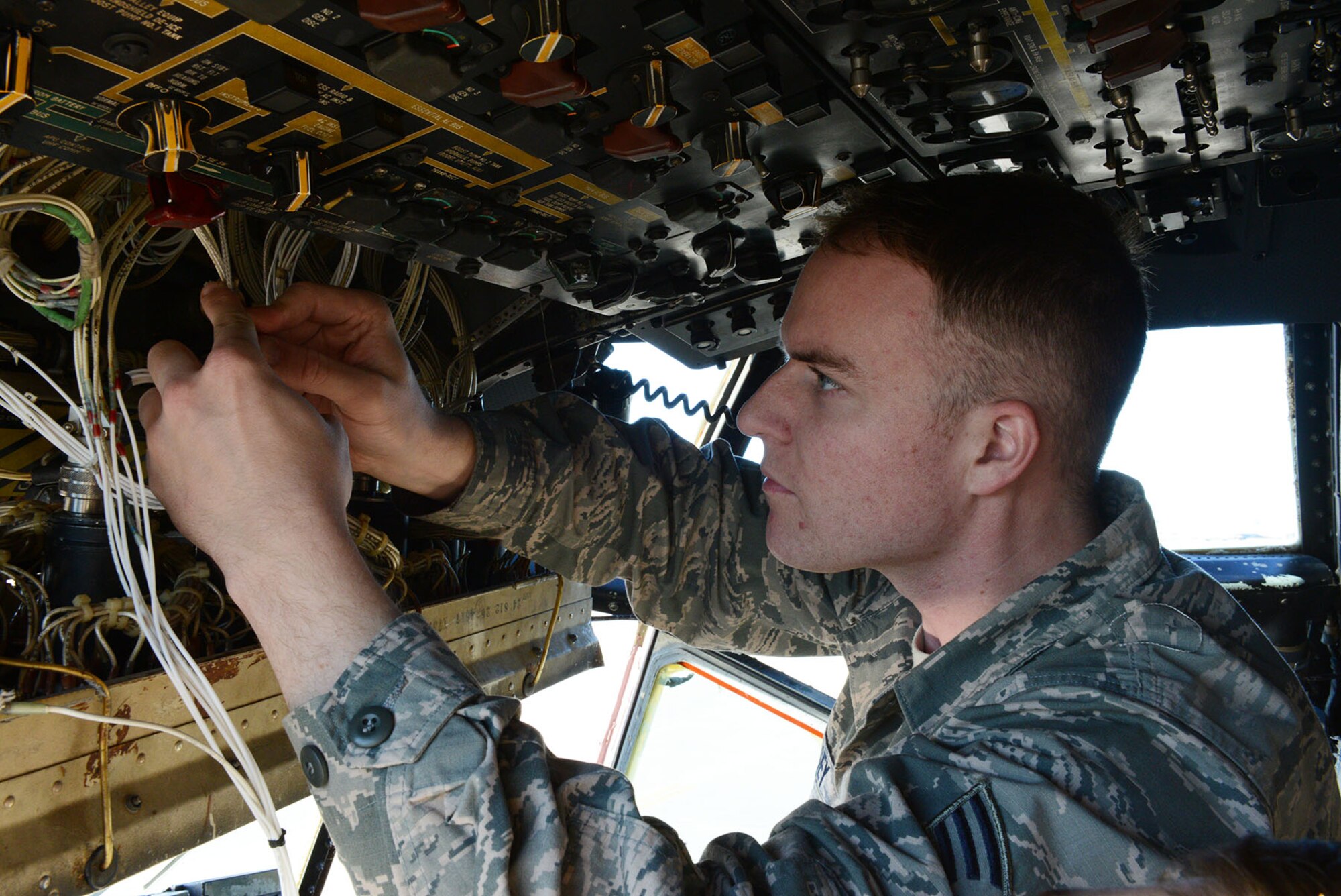 Senior Airman Trey Massey, 374th Aircraft Maintenance Squadron instruments and flight control systems journeyman, removes shielding from a C-130 Hercules fuel quantity indication connector Dec. 2, 2014, at Yokota Air Base, Japan. Wire shielding prevents interference of other electrical signals. (U.S. Air Force photo by Senior Airman Desiree Economides/Released)
