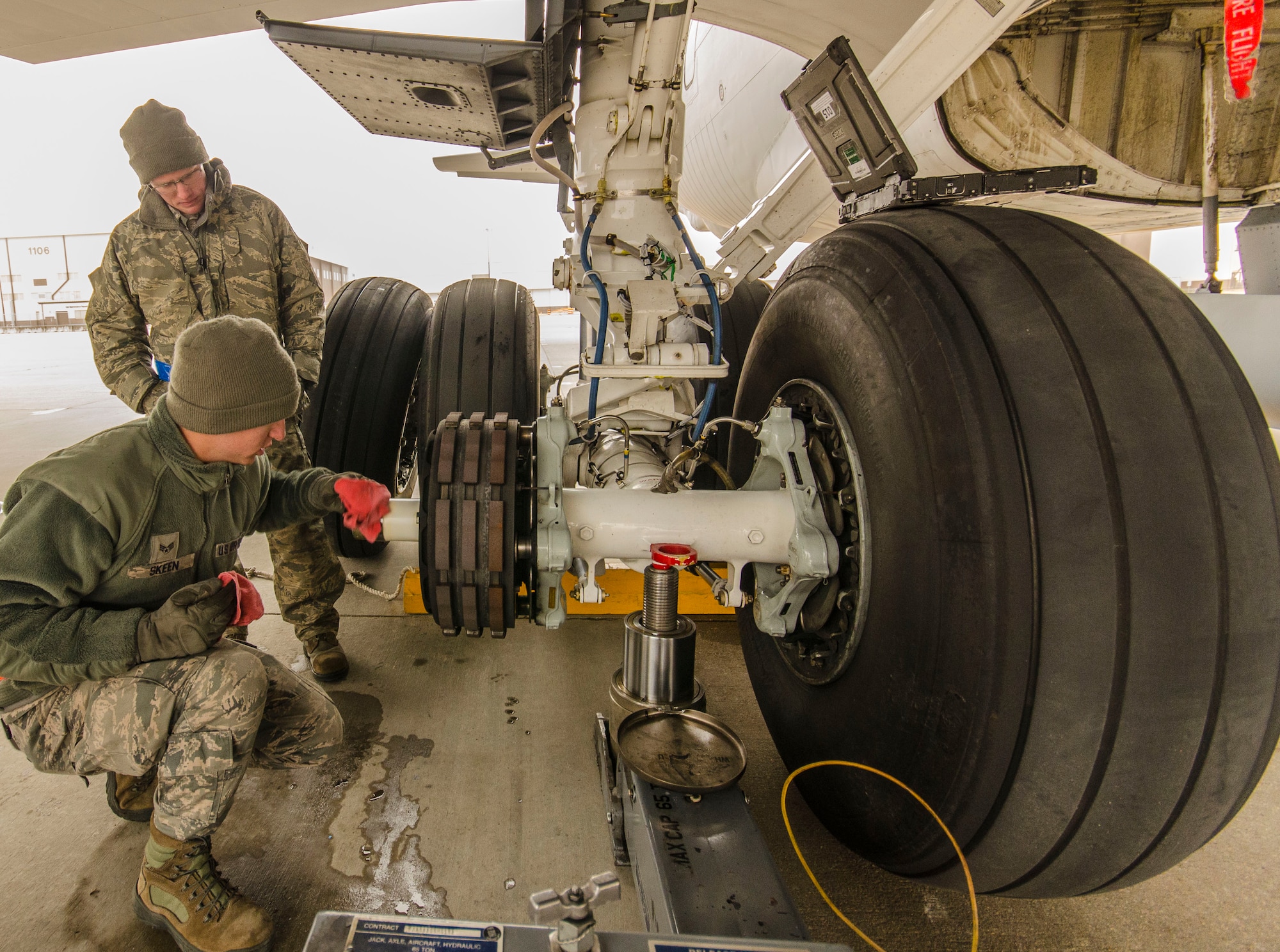 Senior Airman Rilee Skeen, 931st Aircraft Maintenance Squadron, cleans the axle on the main landing gear of a KC-135 Stratotanker during a tire change at McConnell Air Force Base, Kan., Dec. 7, 2014.  The tire change procedure took place during the December Unit Training Assembly and gave members of the 931 MXS an opportunity to refresh practical aircraft maintenance skills.  (U.S. Air Force Photo by Lt. Col. Tsuyoshi Tung)