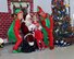 Santa Clause, retired Col. Larry Harrington, and his elves, Airman1st Class Makayla Knight and Senior Airman Damian Huziar,  pose for pictures with the children of unit members in the Air National Guard Hangar at the 185 Air Refueling Wing in Sioux City, Iowa, on December 7, 2014 as part of the holiday project sponsored by the Bats Family Club. (U.S. Air National Guard photo by TSgt. Bill Wiseman/Released)