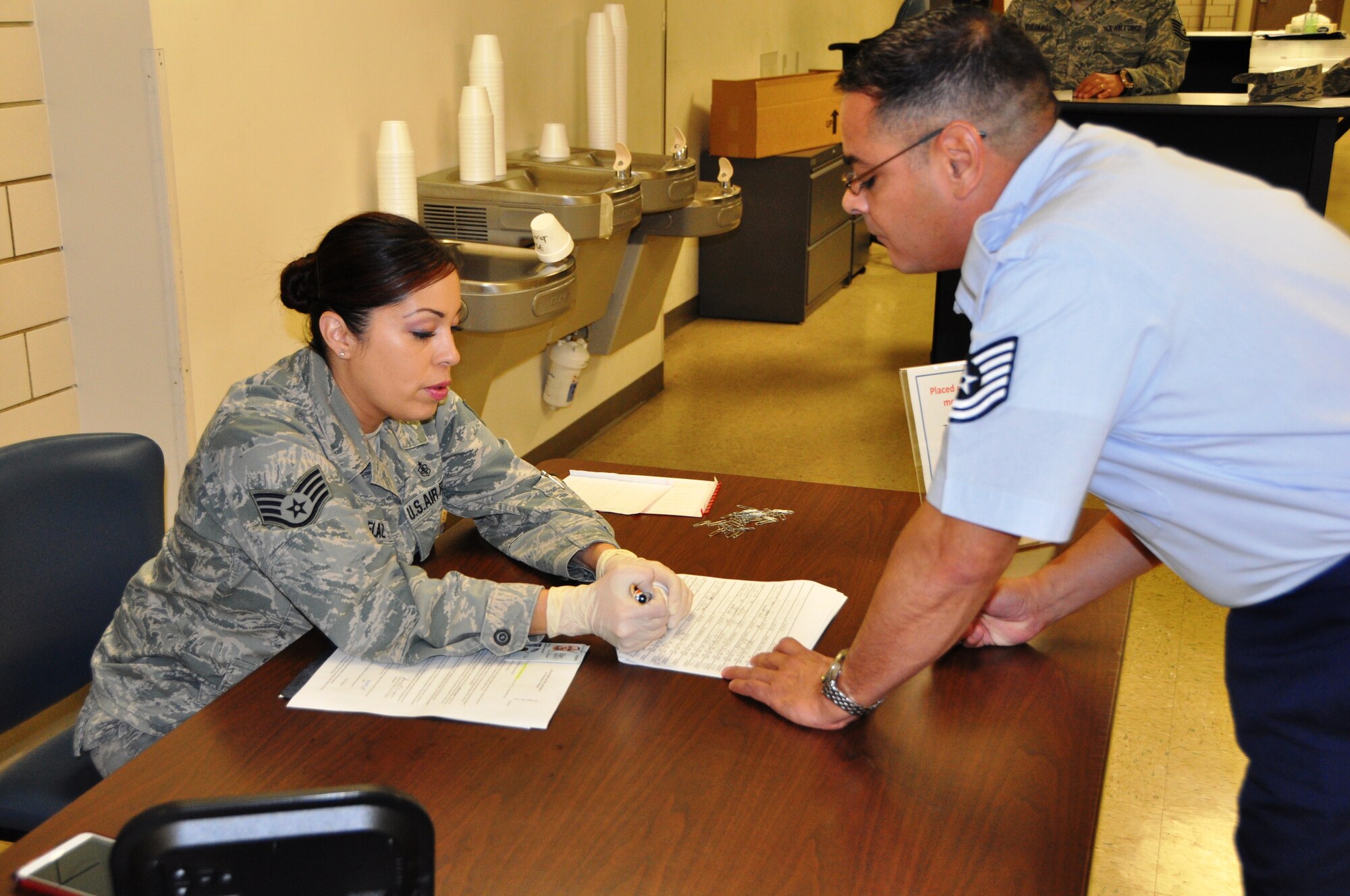 Staff Sgt. Janice Penuelaz, a medical administrative clerk with the 433rd Aerospace Medicine Squadron in-process a Wing member for urinalysis testing, December 6, 2014 at Joint Base San Antonio- Lackland, Texas.   (U.S. Air Force photo by Capt. Cris Medina)