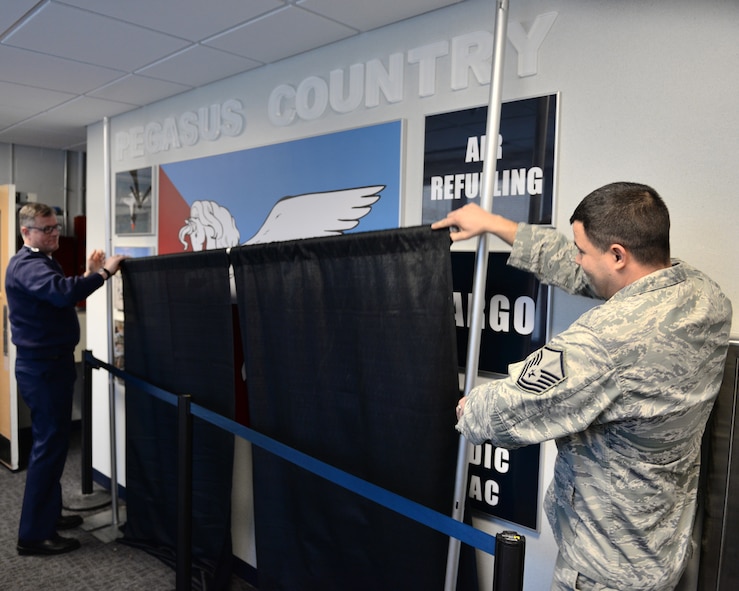 Senior Master Sgt. William Hardekopf (left) and Master Sgt. Bradley Bogue unveil the new Pegasus Country display Dec. 6, 2014 at Pease Air National Guard Base, N.H.  The display represents the mission of the base’s next aircraft, the KC-46 Pegasus.  (U.S. Air National Guard photo by Staff Sgt. Curtis J. Lenz)