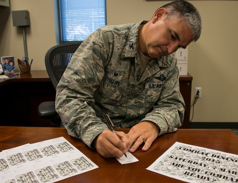 Col. James Phillips, the 919th Special Operations Wing commander, signs the first combat dining-in ticket Dec. 7 at Duke Field, Fla.  The wing will host its first “dining-in” in nine years March 7 at 5 p.m. at the field behind the base dining facility.  The event includes dinner, games and a guest speaker.  Ticket costs are:  E-1 – E-4 $7, E-5-E-6 $10 and E-7 and above $20.  The event is open to all military personnel assigned to the 919th SOW or the Air Force Special Operations Air Warfare Center working on Duke Field.  Contact any 919th SOW chief master sergeant to purchase tickets.  (U.S. Air Force photo/Tech. Sgt. Cheryl Foster)    