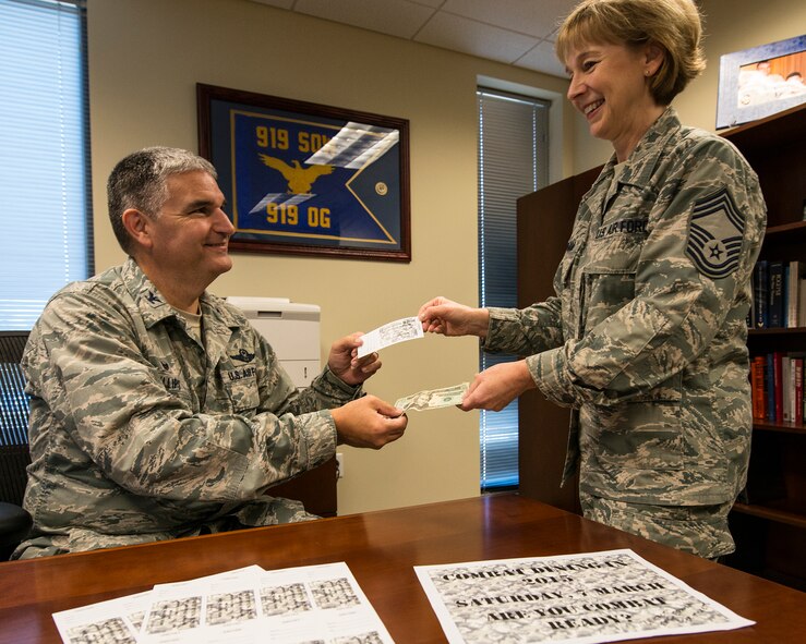 Col. James Phillips, the 919th Special Operations Wing commander, purchases the first combat dining-in ticket from Chief Master Sgt. Karilyn Graham, 919th Force Support Squadron, Dec. 7 at Duke Field, Fla.  The wing will host its first “dining-in” in nine years March 7 at 5 p.m. at the field behind the base dining facility.  The event includes dinner, games and a guest speaker.  Ticket costs are:  E-1 – E-4 $7, E-5-E-6 $10 and E-7 and above $20.  The event is open to all military personnel assigned to the 919th SOW or the Air Force Special Operations Air Warfare Center working on Duke Field.  Contact any 919th SOW chief master sergeant to purchase tickets.  (U.S. Air Force photo/Tech. Sgt. Cheryl Foster)   