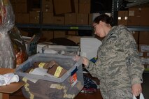 2nd Lt. Marilyn Miquel, 512th Operations Support Squadron, sifts through new clothing articles offered by USO Delaware during the nonprofit organization’s holiday giveaway Dec. 6, 2014, at Dover Air Force Base, Del. The various available items military members and their families could choose from were new clothing articles, snacks and toiletries. (U.S. Air Force photo/Senior Airman Joe Yanik)