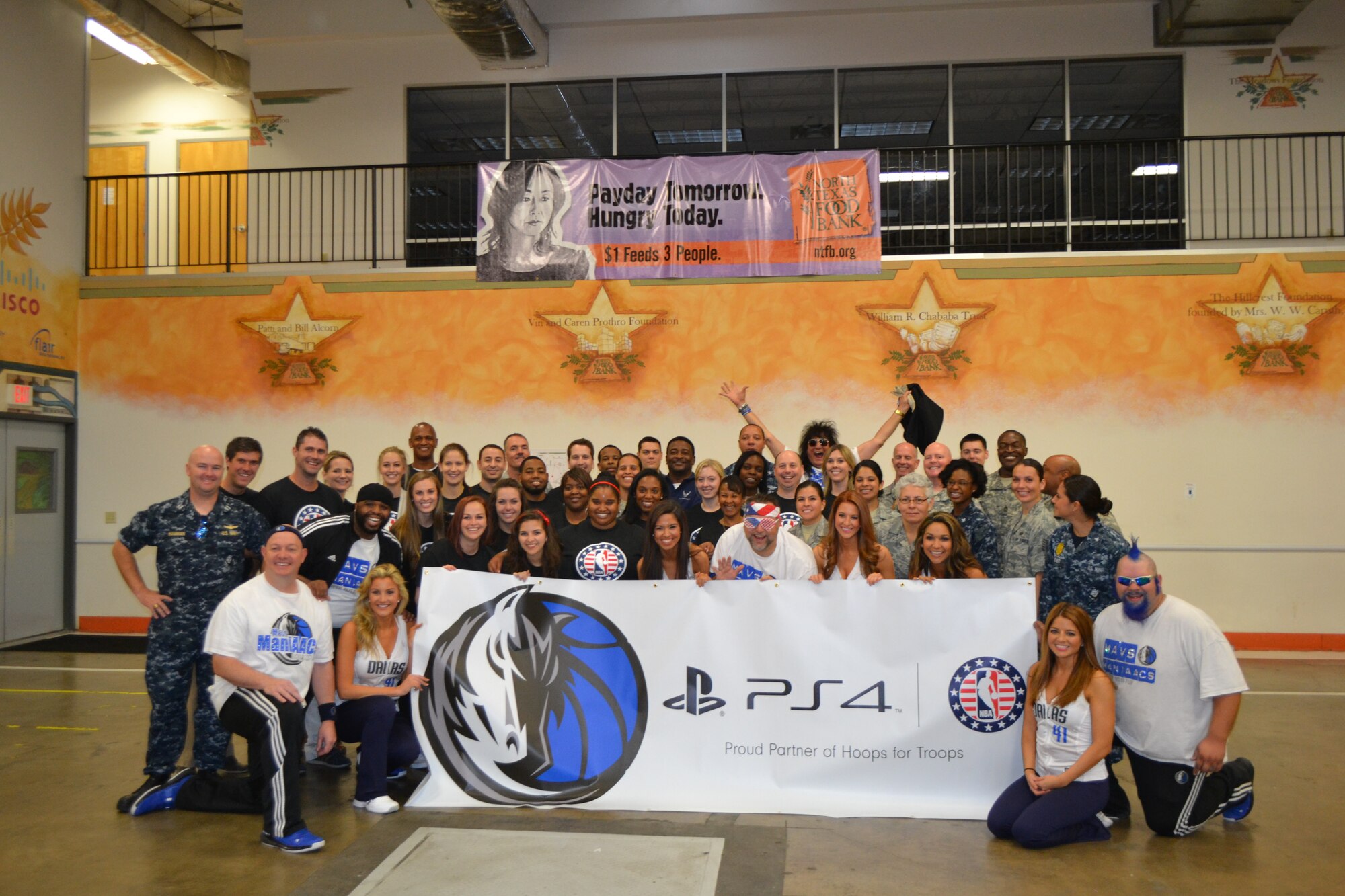 Members of 301st Fighter Wing, 10th Air Force, a local Army unit, and Navy personnel from Naval Air Station Fort Worth Joint Reserve Base, Texas, kick off the Commitment to Service program with the Dallas Mavericks at the North Texas Food Bank Nov. 4 in Dallas.  The food bank announced that the effort provided 4,550 meals to underprivileged children in the Dallas and Fort Worth area. (U.S. Air Force photo by Mr. Shawn McCowan)