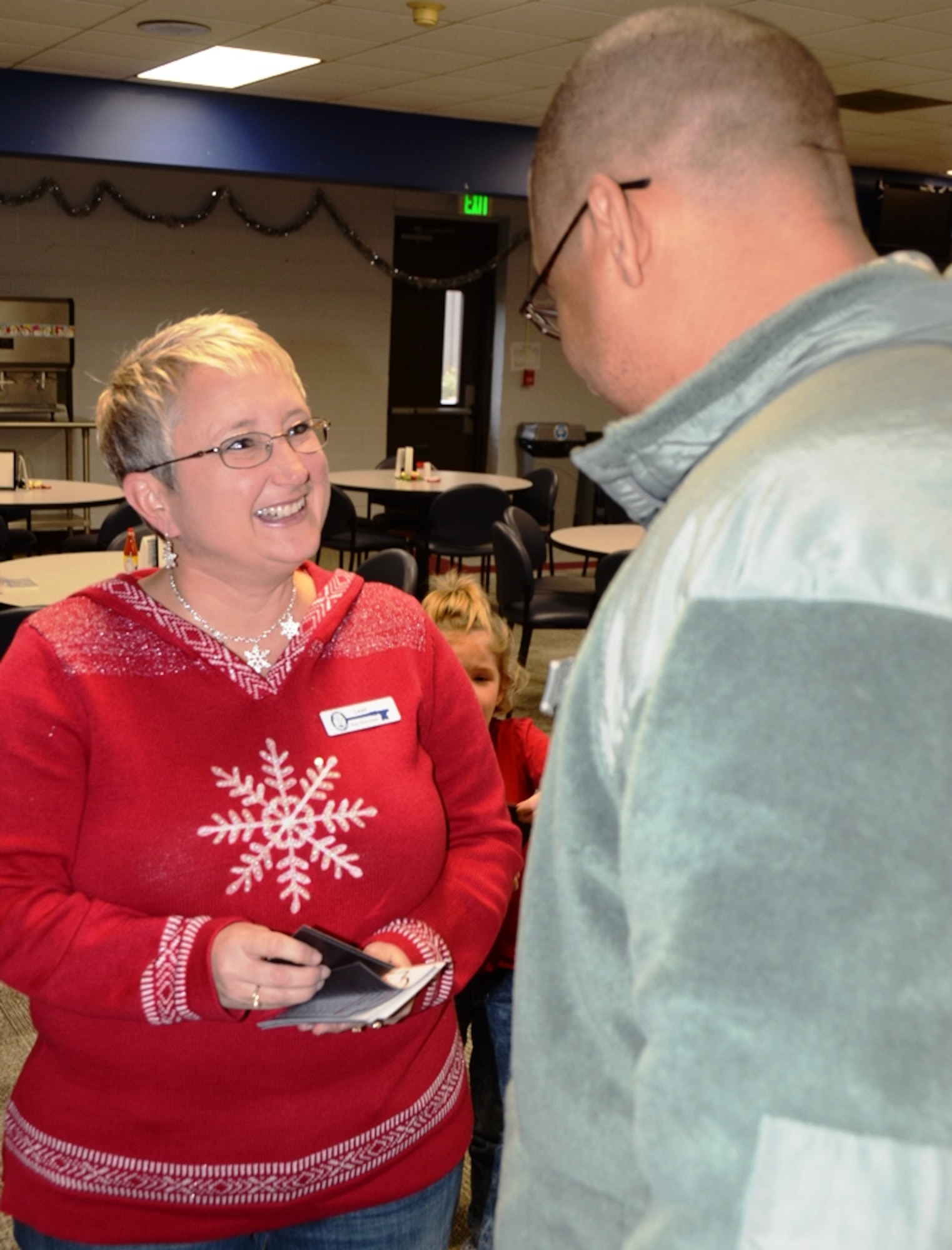 Stacy Morse, Key Volunteer Mentor for the 175th Wing in Baltimore, Md., hands out drill schedule magnets to Maryland Air National Guard members during the December drill. (U.S. Air National Guard photo by Tech. Sgt. David Speicher/RELEASED)