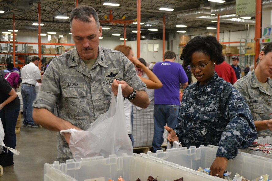 Col. Bill Lyons, 10th Air Force Assistant Vice Commander, left, joined members of 301st Fighter Wing, a local Army unit, and Navy personnel from Naval Air Station Fort Worth Joint Reserve Base, Texas, kicked off the Commitment to Service program with the Dallas Mavericks at the North Texas Food Bank Nov. 4 in Dallas.  The food bank announced that the effort provided 4,550 meals to underprivileged children in the Dallas and Fort Worth area. (U.S. Air Force photo by Mr. Shawn McCowan)