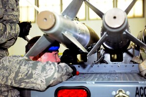 141206-Z-EZ686-007 –Senior Airman Welsey Retka of the 127th Maintenance Group prepares to load a simulated bomb during a Loadeo contest at Selfridge Air National Guard Base Mich., Dec. 6, 2014.  The Loadeo contest is an annual contest with three competing teams that are scored for their ability to load missiles accurately and in a timely manner. (U.S. Air National Guard photo by MSgt. David Kujawa/Released)