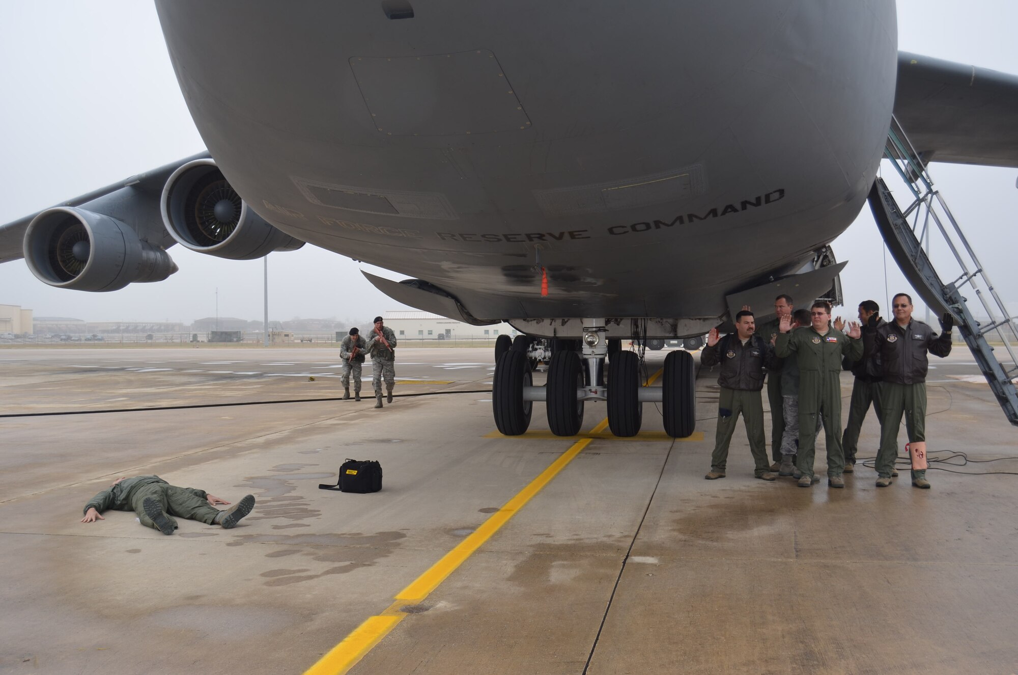 Two members of the 802nd Security Forces Squadron prepare to engage the hijacker and hostages underneath a C-5A Galaxy on the 433rd Airlift Wing flight line during the anti-hijacking exercise held Dec. 5, 2014 on Joint Base San Antonio-Lackland, Texas. (U.S. Air Force Photo/ Maj. Tim Wade)