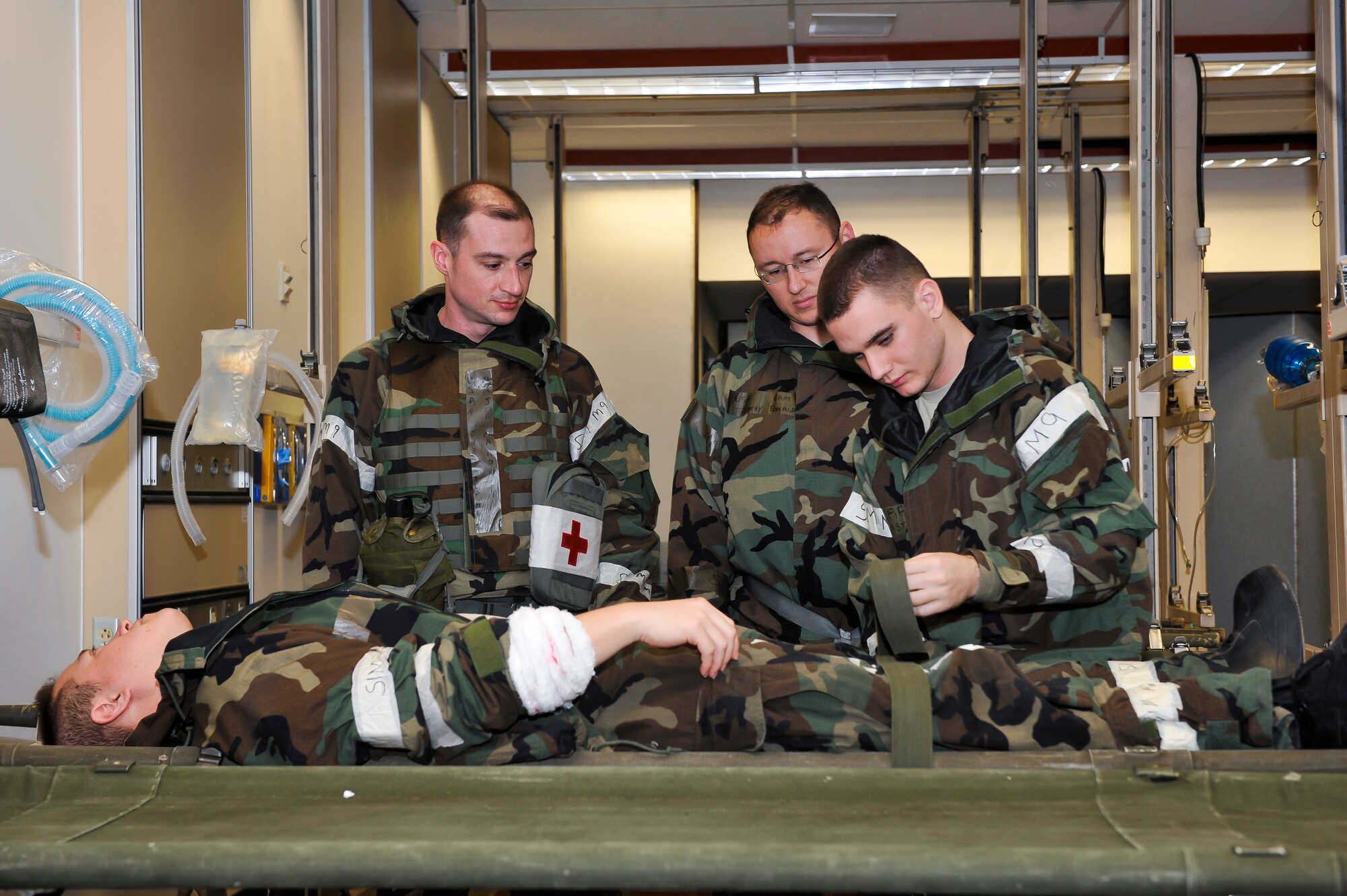 Airman 1st Class Christian Ortiz, 51st Medical Operations Squadron aerospace medical technician, tightens the straps on Master Sgt. Donald Prothero, 51st Medical Group education and training flight chief, to keep him stable Dec. 6, 2014 at Osan Air Base, Republic of Korea. The exercise focuses on readiness, testing Osan’s wartime procedures, and realistically looking at our ability to defend the base, execute operations and receive follow-on forces. (U.S. Air Force photo by Senior Airman David Owsianka)