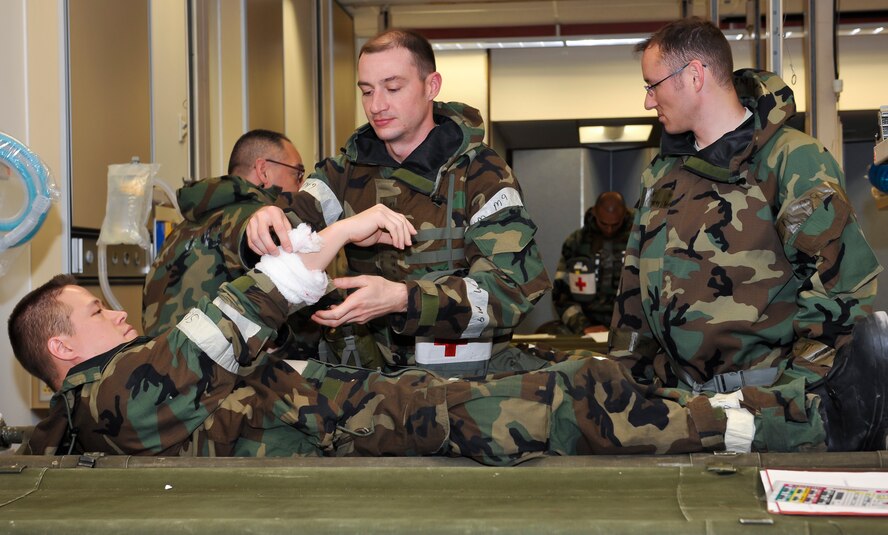 Maj. Christopher Mahoney, 51st Medical Operations Squadron general surgeon, evaluates a simulated forearm wound on Master Sgt. Donald Prothero, 51st Medical Group education and training flight chief, at Osan Air Base, Republic of Korea, Dec. 6, 2014. The disaster team performs operations on a variety of injuries such as gunshot and shrapnel wounds, burns, wounds from explosions or abdominal injuries. (U.S. Air Force photo by Senior Airman David Owsianka)