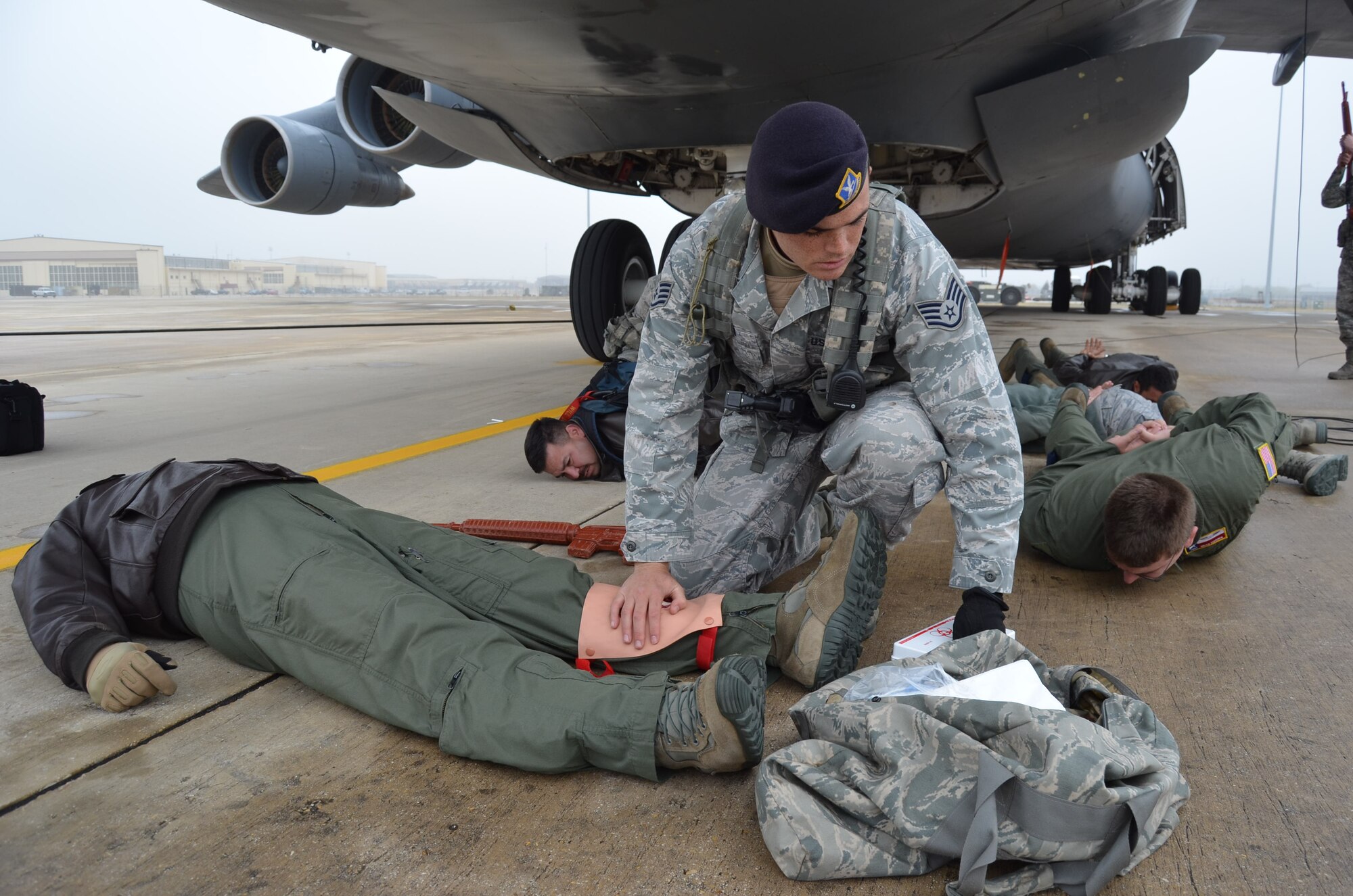 Staff Sgt. Richard Lotterer, 802nd Security Forces Squadron, renders first aid to Master Sgt. Michael Jones, 68th Airlift Squadron, during the anti-hijacking exercise held Dec. 5, 2014 on Joint Base San Antonio-Lackland, Texas. (U.S. Air Force Photo/ Maj. Tim Wade)