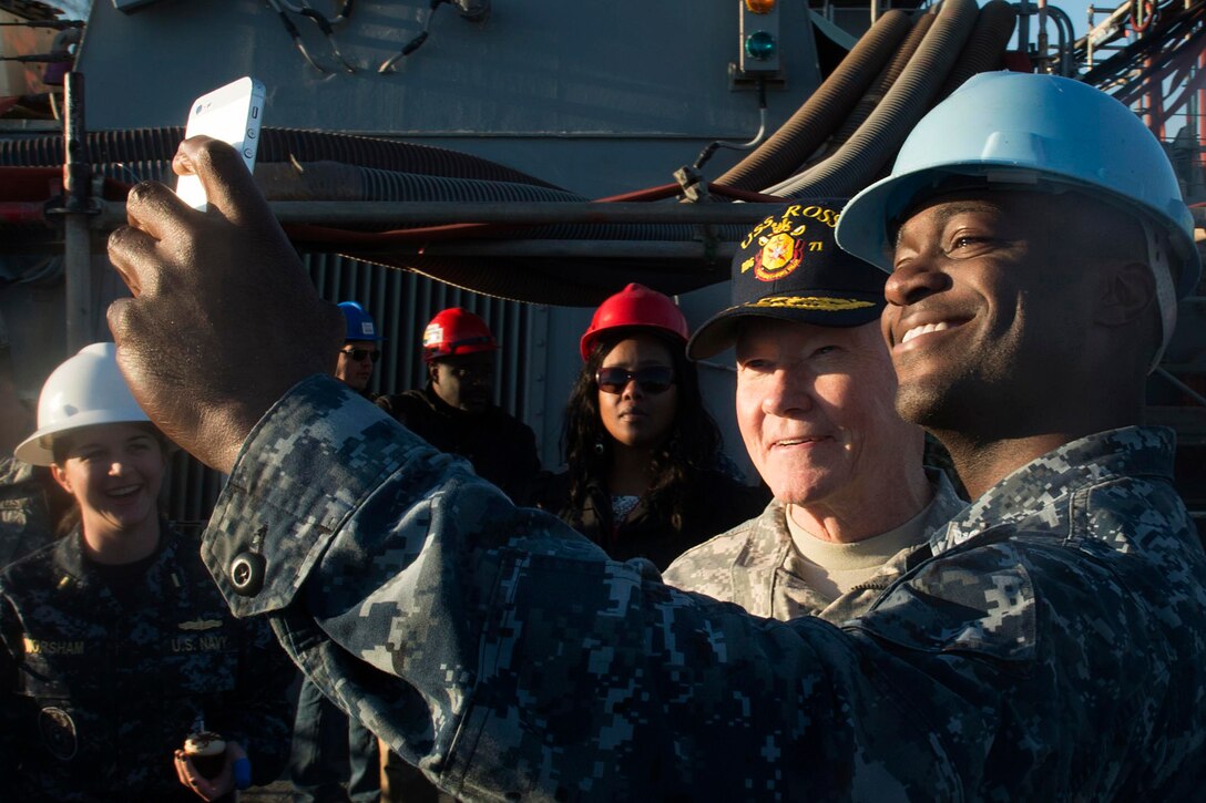 U.S. Army Gen. Martin E. Dempsey, chairman of the Joint Chiefs of Staff, takes a photo with a U.S. sailor while aboard the USS Donald K. Ross on Naval Station Rota, Spain, Dec. 6, 2014. Dempsey is visiting U.S. service members who are deployed outside the United States during the holidays. DoD photo by D. Myles Cullen