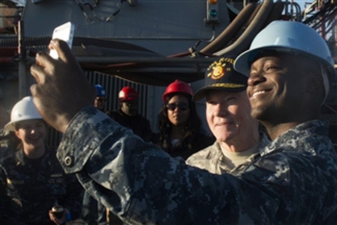 U.S. Army Gen. Martin E. Dempsey, chairman of the Joint Chiefs of Staff, takes a photo with a U.S. sailor while aboard the USS Ross on Naval Station Rota, Spain, Dec. 6, 2014. Dempsey is visiting U.S. service members who are deployed outside the United States during the holidays. 