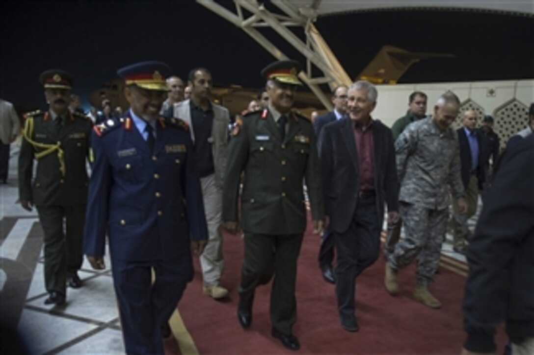 U.S. Defense Secretary Chuck Hagel, center right, walks with Kuwaiti Army Chief of Staff Lt. Gen. Mohammad Al-Khoder as he arrives at the Kuwait International Airport, Kuwait, Dec. 7, 2014. 