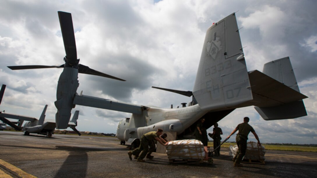 U.S. Marines and Sailors with SPMAGTF Crisis Response - Africa prepare to load bags of concrete onto an MV-22B Osprey to help local and international health organizations build Ebola Treatment Units while in support of Operation United Assistance in Monrovia, Liberia, Nov. 21, 2014. United Assistance is a Department of Defense operation to provide command and control, logistics, training, and engineering support to U.S. Agency for International Development- led efforts to contain the Ebola virus outbreak in West African nations. (U.S. Marine Corps photo by Lance Cpl. Andre Dakis/SPMAGTF-CR-AF Combat Camera/Released)