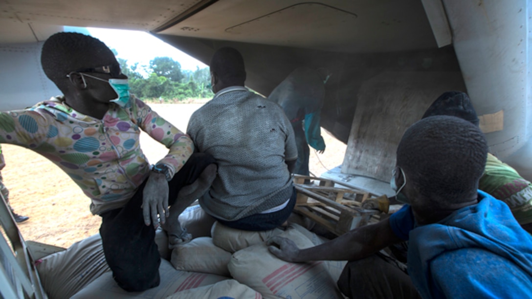 Members of Samaritan's Purse, an international relief group, finish offloading bags of concrete from an MV-22B Osprey, assigned to SPMAGTF Crisis Response – Africa, that will be used to build Ebola Treatment Units while in support of Operation United Assistance in Monrovia, Liberia, Nov. 21, 2014. United Assistance is a Department of Defense operation to provide command and control, logistics, training, and engineering support to U.S. Agency for International Development- led efforts to contain the Ebola virus outbreak in West African nations. (U.S. Marine Corps photo by Lance Cpl. Andre Dakis/SPMAGTF-CR-AF Combat Camera/Released)