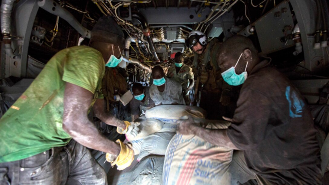 U.S. Navy Lt. Jeffery Fornadley, a flight surgeon with SPMAGTF Crisis Response – Africa, helps members of Samaritan's Purse, an international relief group, offload, from an MV-22B Osprey, bags of concrete that will be used to by health organizations to build Ebola Treatment Units, while in support of Operation United Assistance in Fish Town, Liberia, Nov. 21, 2014. United Assistance is a Department of Defense operation to provide command and control, logistics, training, and engineering support to U.S. Agency for International Development- led efforts to contain the Ebola virus outbreak in West African nations. (U.S. Marine Corps photo by Lance Cpl. Andre Dakis/SPMAGTF-CR-AF Combat Camera/Released)