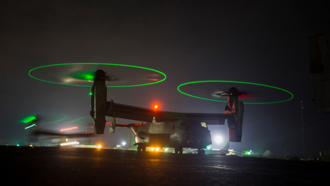 U.S. Marine Corps MV-22B Ospreys with SPMAGTF - Crisis Response - Africa prepare to fly at night as part of required training standards in order for pilots to continue to be qualified to carry passengers at night. while in support of Operation United Assistance in Monrovia, Liberia, Nov. 16, 2014. United Assistance is a Department of Defense operation to provide command and control, logistics, training and engineering support to U.S. Agency for International Development- led efforts to contain the Ebola virus outbreak in West African nations. (U.S. Marine Corps photo by Lance Cpl. Andre Dakis/SP-MAGTF Crisis Response Africa Combat Camera/Released)