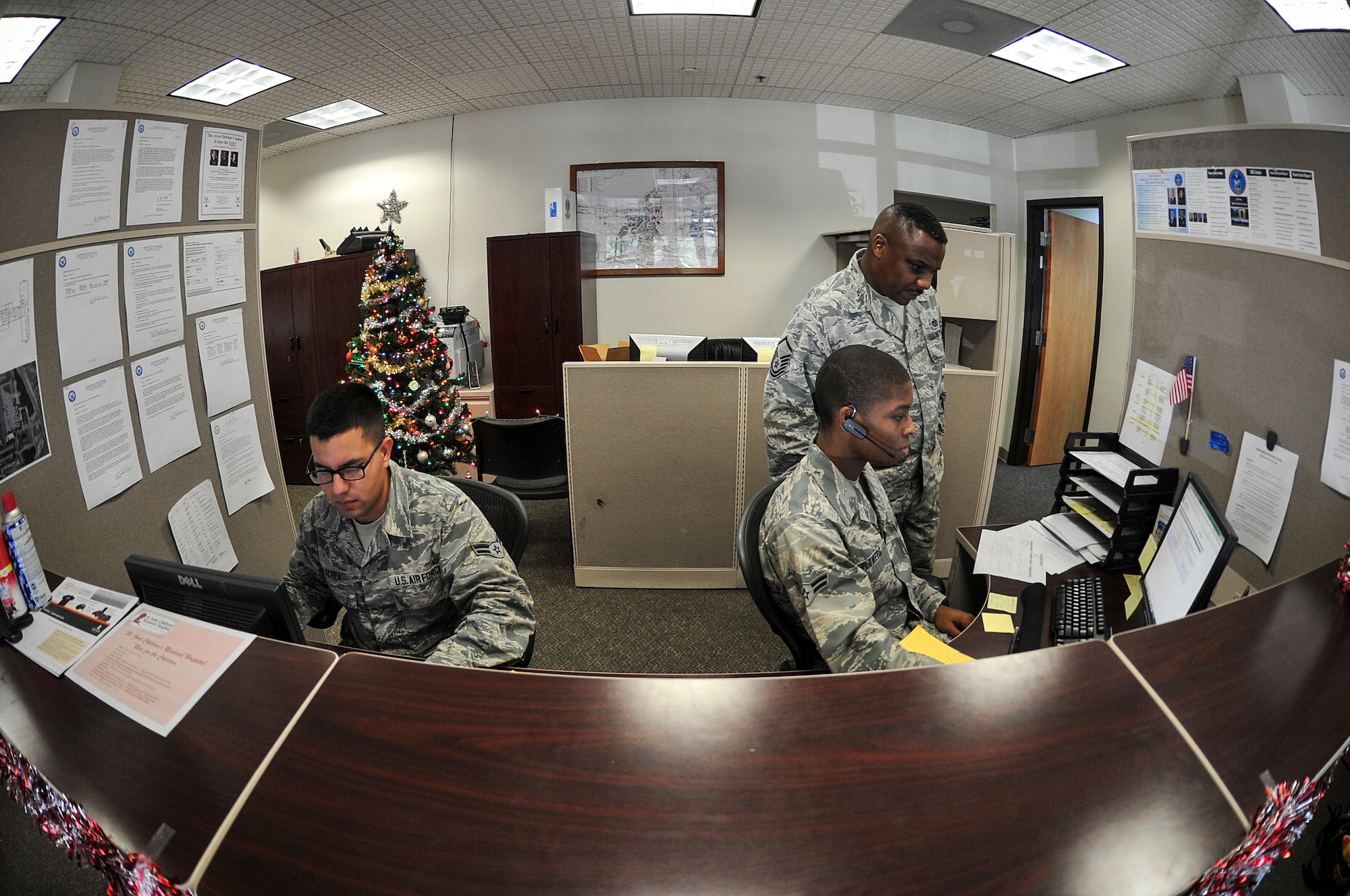 Airman 1st Class Joseph Olachea and Airman 1st Class Charles Flowers, 1st Special Operations Civil Engineering Squadron civil engineer journeyman process work order requests at the “Fish Bowl” on Hurlburt Field, Fl., Dec. 4, 2014. The Fish Bowl is the nickname for the customer service office at the 1 SOCES. (U.S. Air Force photo/Airman 1st Class Jeff Parkinson)