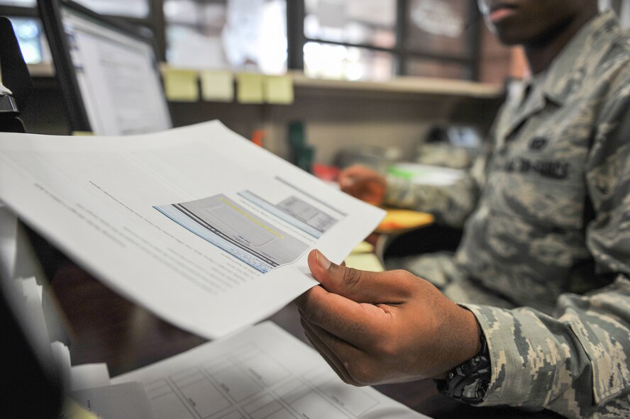 Airman 1st Class Charles Flowers, 1st Special Operations Civil Engineer Squadron civil engineer journeyman files paperwork at the “Fish Bowl”, Hurlburt Field, Fla., Dec. 4, 2014. Airmen at the Fish Bowl take calls and create work orders for various shops at the 1st SOCES to complete around the base. (U.S. Air Force photo/Airman 1st Class Jeff Parkinson) 