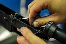 Senior Airman Christopher Crawley, 1st Special Operations Security Forces Squadron Combat Arms Training and Maintenance instructor, replaces a hammer spring on an M4 rifle at Hurlburt Field, Fla., December 2, 2014. CATM instructors provide firing training and maintain all weapons used by CATM and Security Forces. (U.S. Air Force photo/Airman 1st Class Jeff Parkinson)