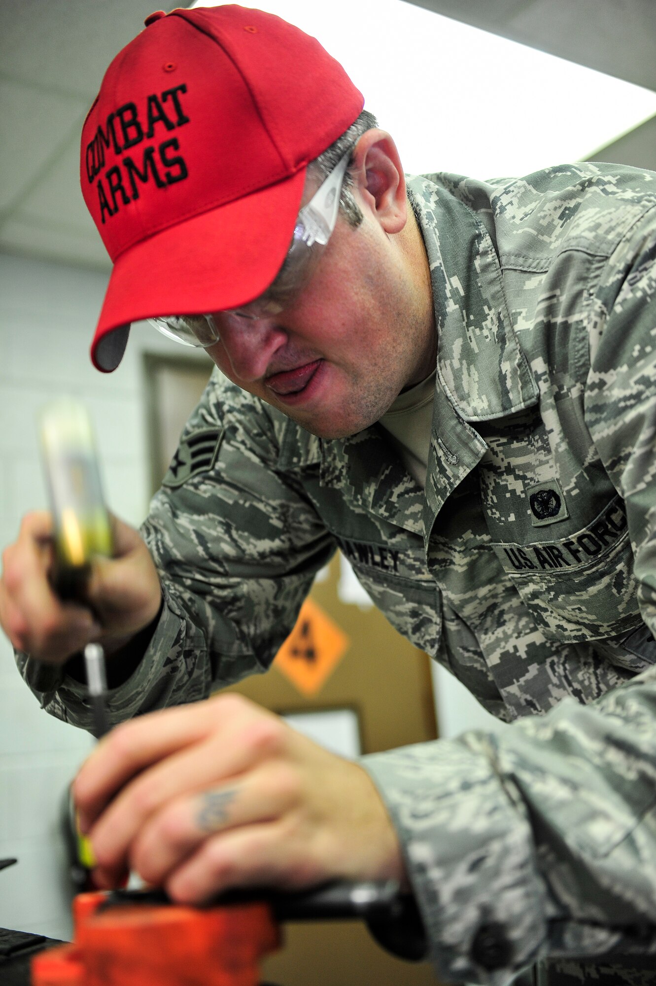 Senior Airman Christopher Crawley, 1st Special Operations Security Forces Squadron Combat Arms Training and Maintenance instructor, removes a pin from an M9 pistol at Hurlburt Field, Fla., December 2, 2014. CATM instructors not only provide firing training, but they also maintain all weapons used by CATM and Security Forces. (U.S. Air Force photo/Airman 1st Class Jeff Parkinson)