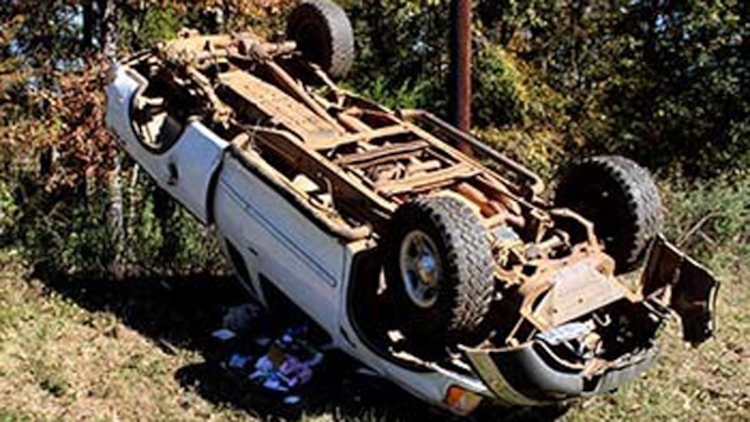 Marines with Bravo Company, 1st Battalion, 23rd Marine Regiment, 4th Marine Division, were the first on the scene of this overturned truck Nov. 26, 2014, after conducting a funeral detail. The woman inside, Patti Cranford, of Garrison, Texas, was on her way to the funeral when she lost control of her vehicle a mile away from the cemetery. (Photo by Scott Flowers)
